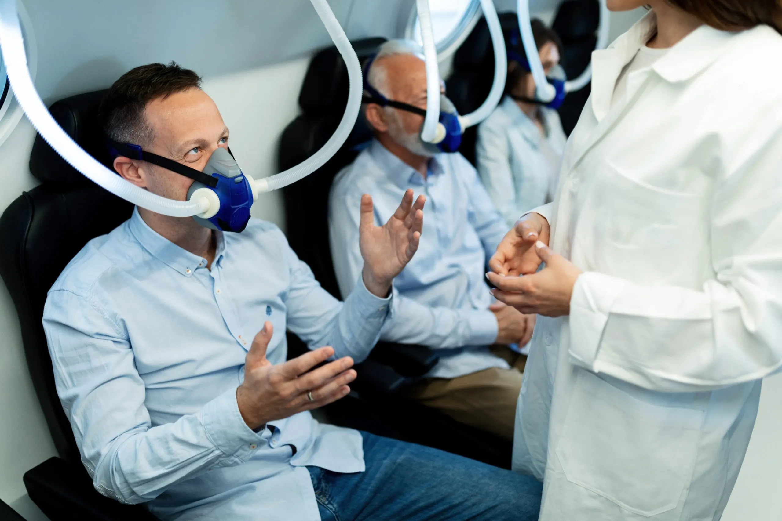 Australia CPAP Machines Market Outlook to 2030 happy-man-wearing-oxygen-mask-talking-female-doctor-hyperbaric-chamber-clinic-scaled