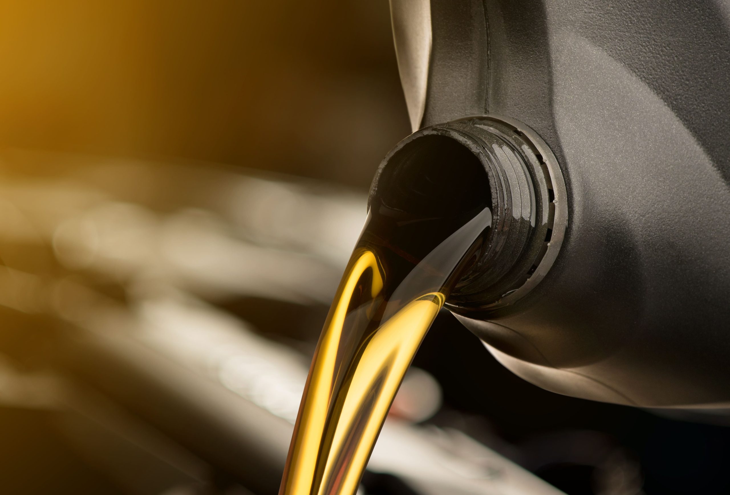 pouring-oil-lubricant-motor-car-from-black-bottle-isolated-white-background-1-scaled