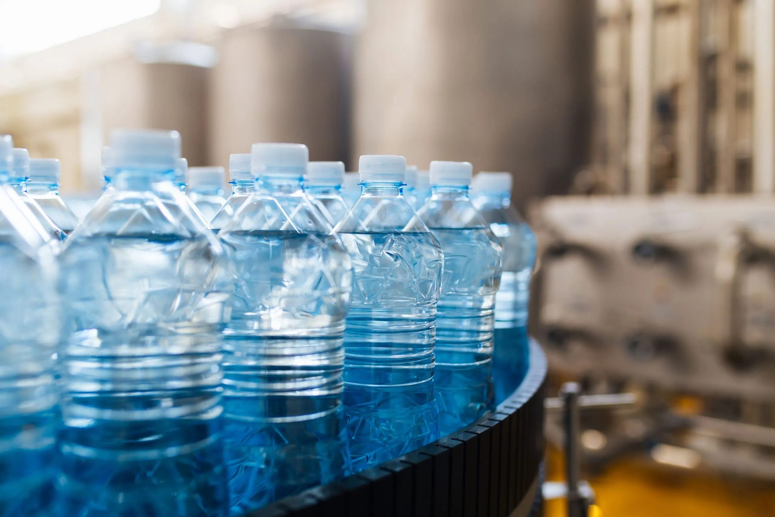 Indonesia Packaged Water Market Outlook to 2030 water-bottling-line-processing-bottling-pure-spring-water-into-blue-bottles-1-scaled