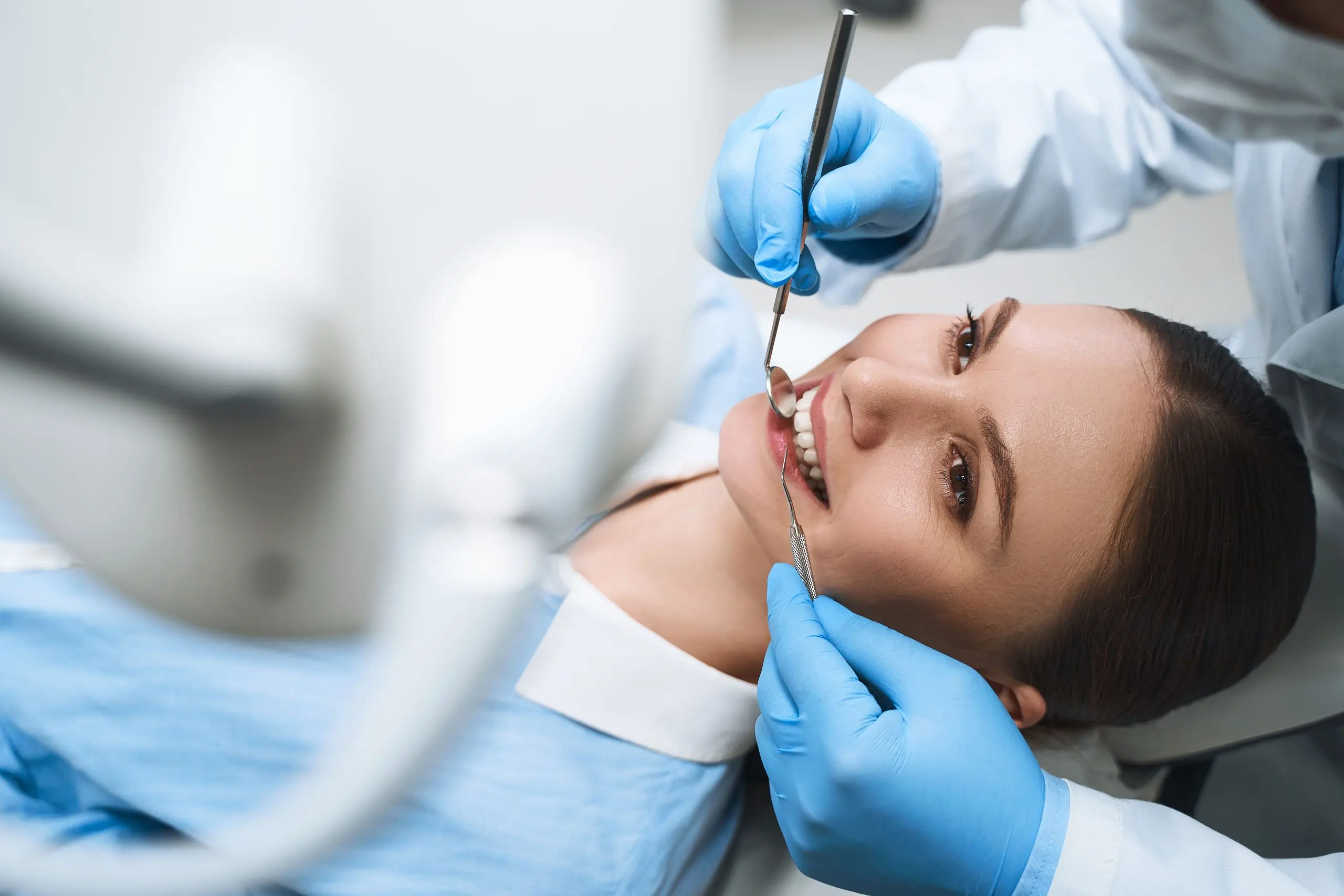 India Dental Services Market Outlook to 2030 cheerful-young-lady-is-coming-dental-clinic-enjoying-check-up-with-explorer-mirror-1-scaled