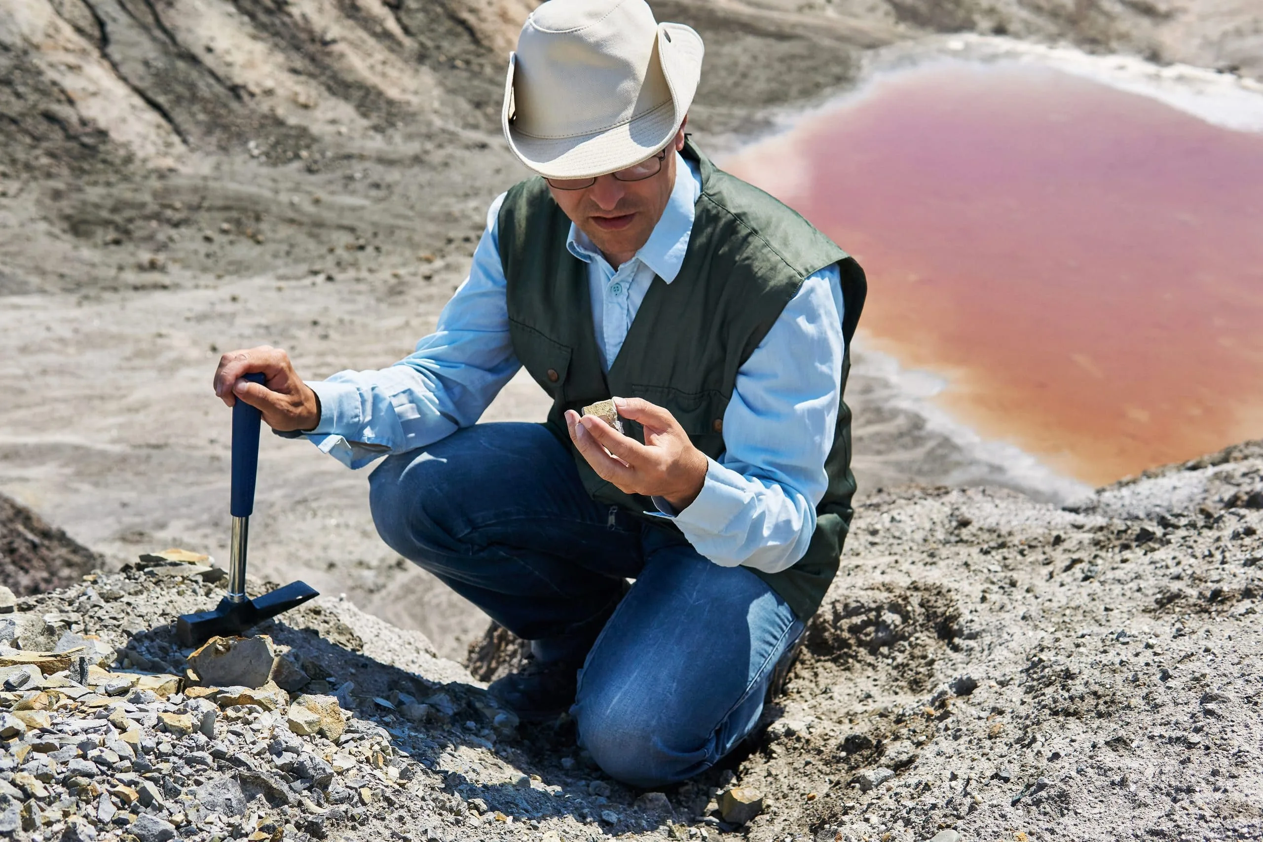 Supporting Sarathy Geotech with End-User Insights for Deep Foundation Testing in KSA man-geologist-desert-area-examines-rock-sample-against-backdrop-colored-salt-lake-1-scaled
