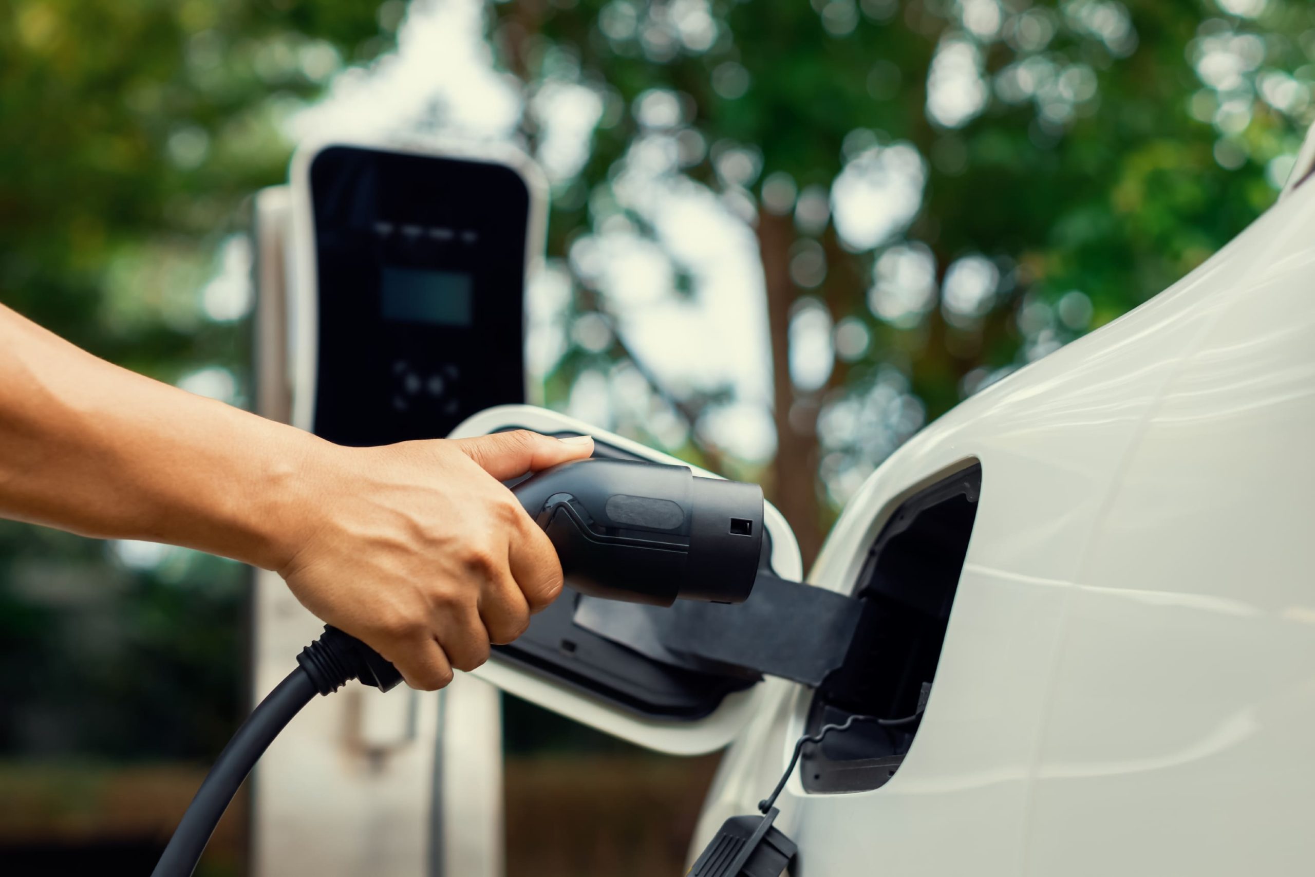 KSA EV Charging Stations Market Outlook to 2030 focus-hand-insert-progressive-ev-charger-plug-ev-car-with-blur-background-1-scaled