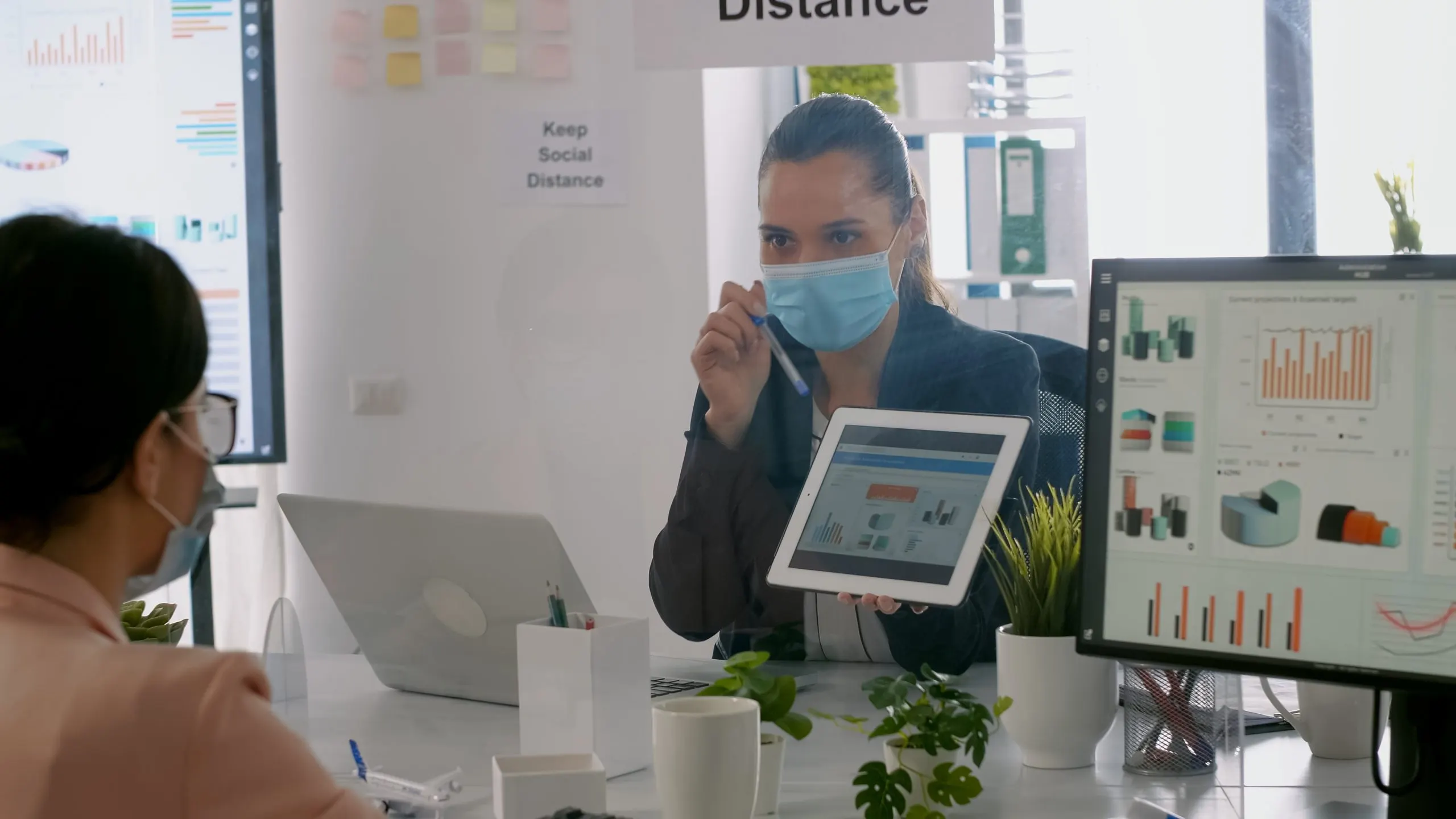 Philippines HbA1c Monitoring Devices Market Outlook 2030 back-shot-business-womens-with-medical-face-mask-working-together-management-presentation-using-tablet-computer-while-sitting-company-office-team-respecting-social-distance-scaled