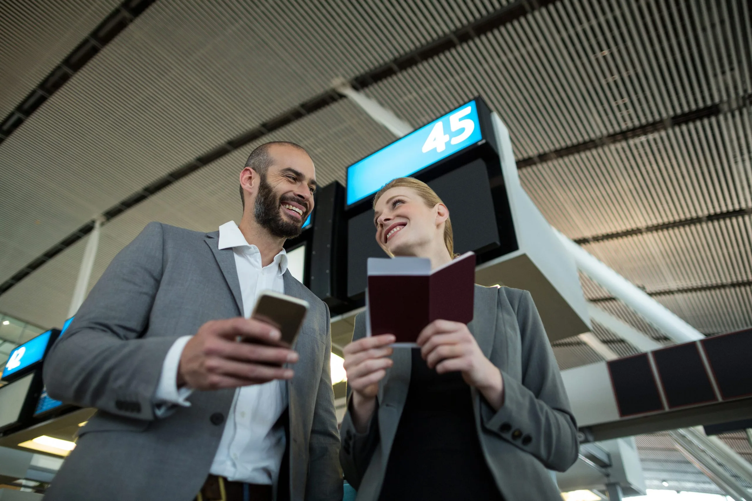 UAE inflight entertainment and connectivity Market outlook 2035 business-people-holding-boarding-pass-using-mobile-phone-1-scaled