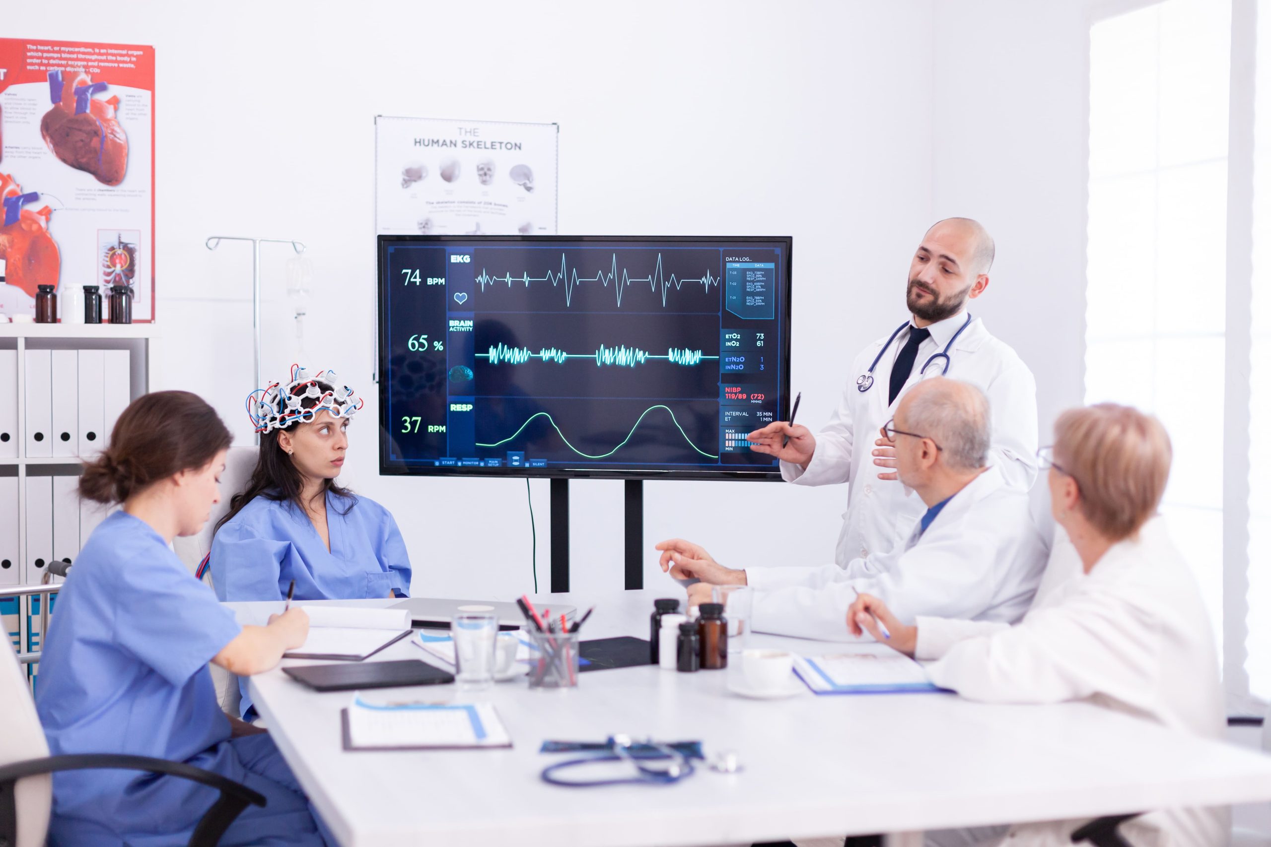 UAE Cardiac Biomarkers Market Outlook 2030 doctor-discussing-about-future-neurology-with-medical-staff-hospital-meeting-room-monitor-shows-modern-brain-study-while-team-scientist-adjusts-device-1-scaled
