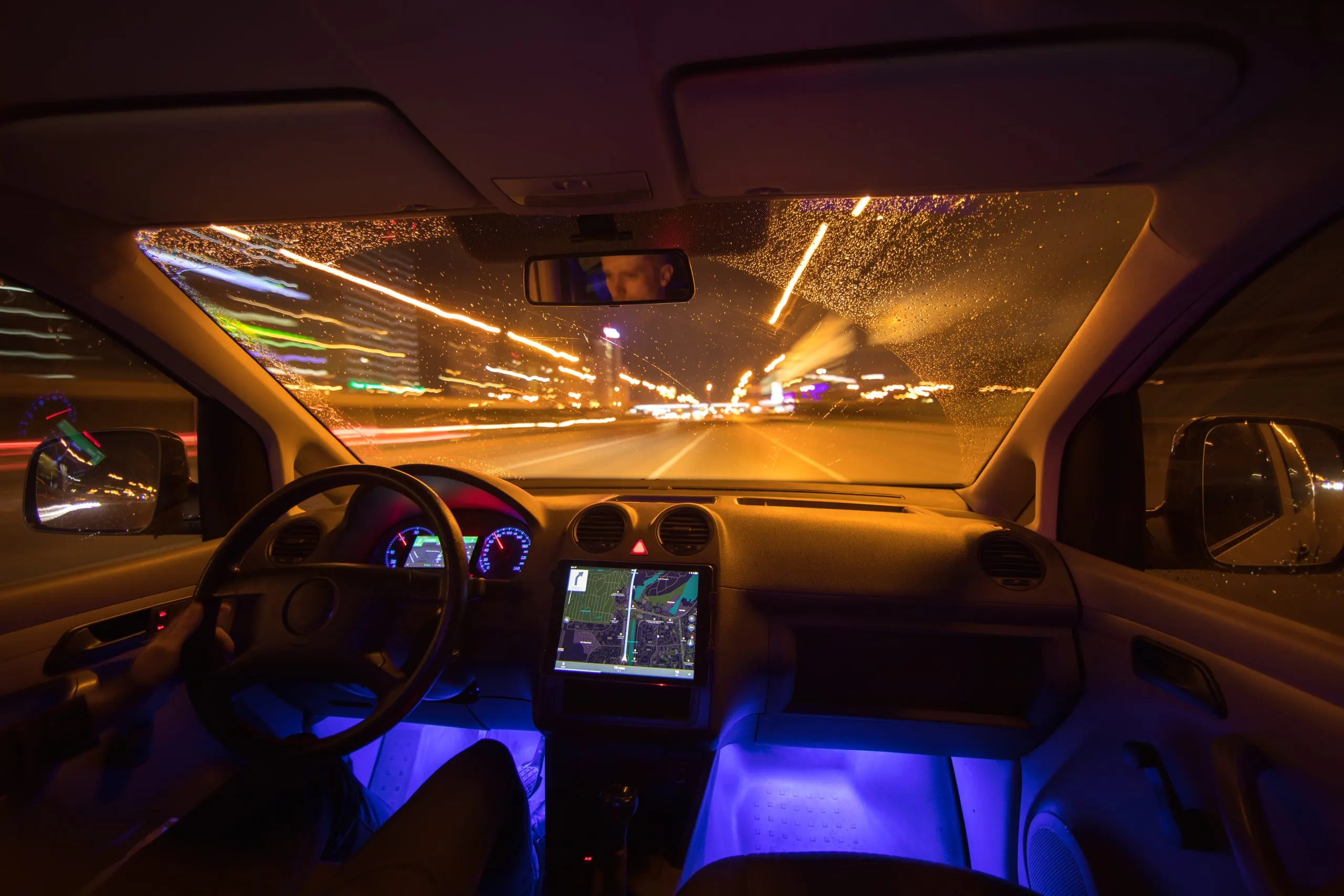 USA Interior Lighting Market Outlook 2030 man-drive-with-navigation-rain-city-inside-view-evening-night-time-scaled