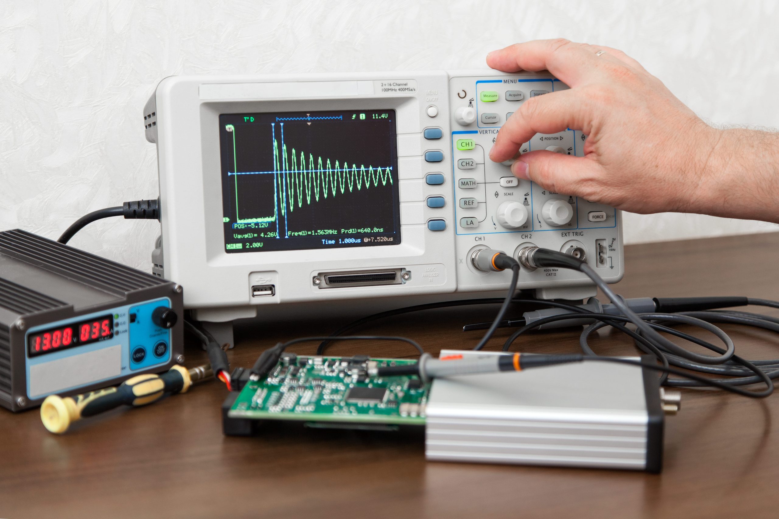 man-hand-turning-signal-adjustment-knob-oscilloscope-1-scaled