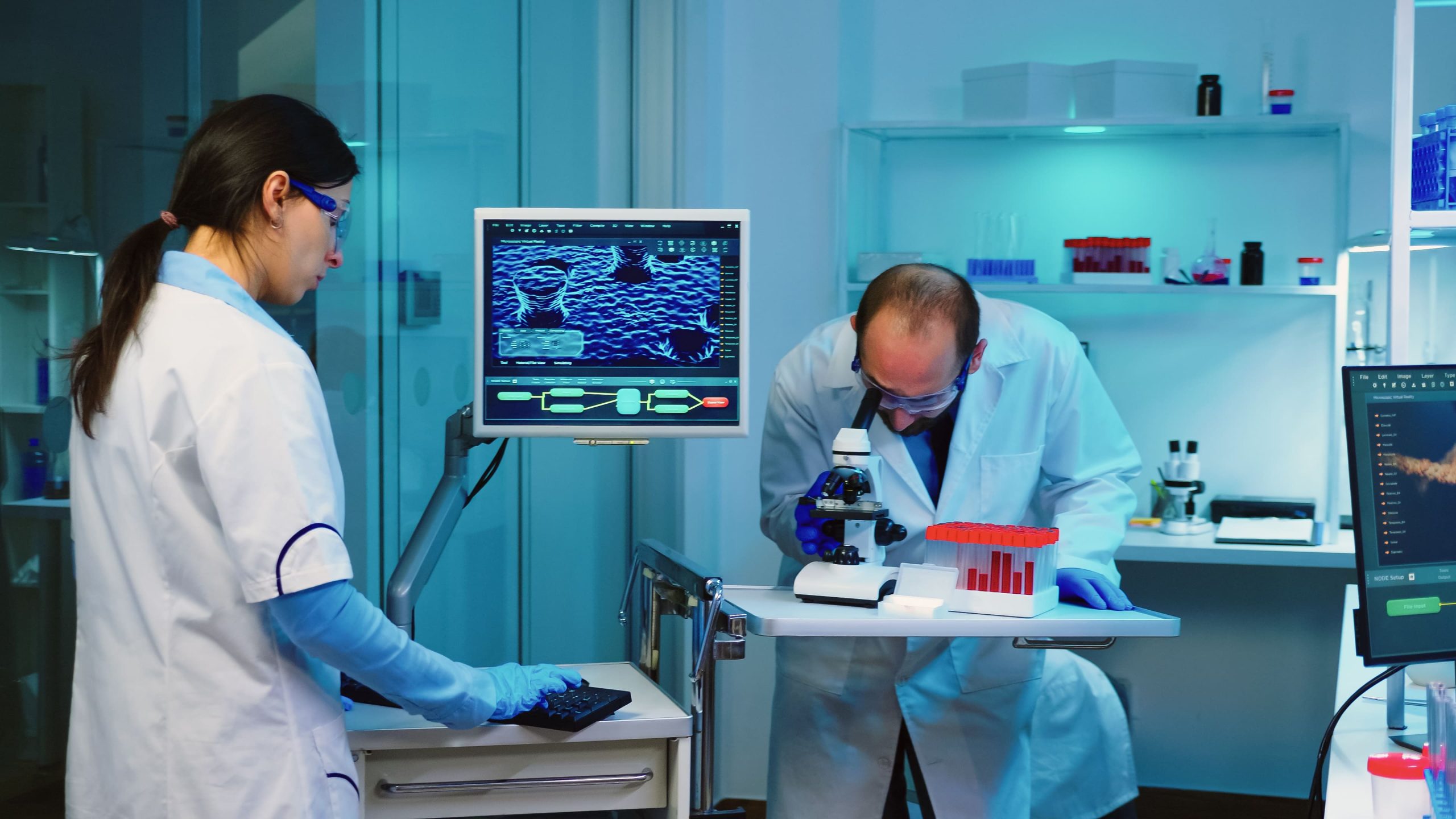 KSA Coronary Artery Imaging Equipment Market Outlook 2030 scientist-researcher-using-microscope-laboratory-while-nurse-taking-notes-computer-working-overtime-1-scaled