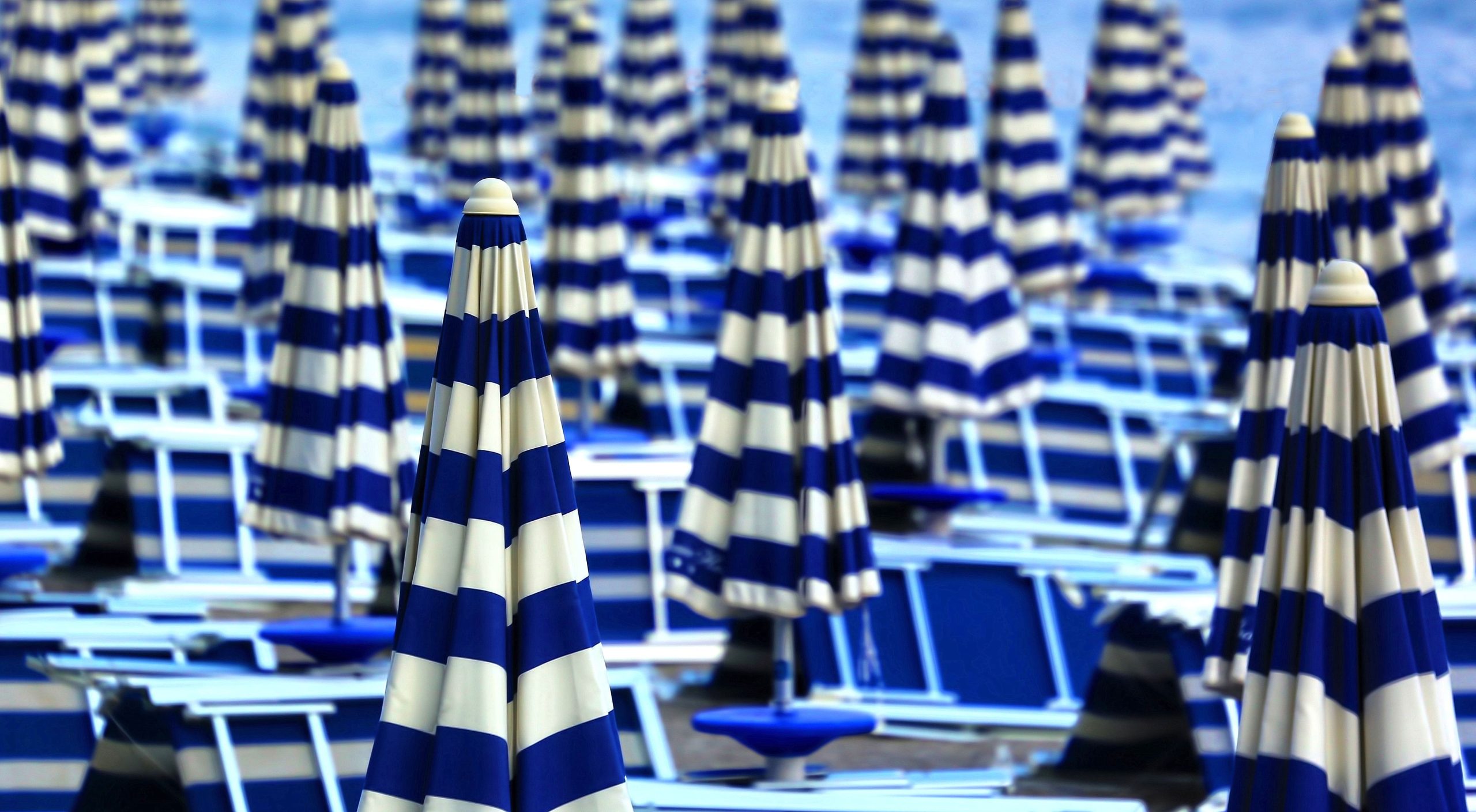 white-blue-patio-umbrella-lot-daytime-1-scaled