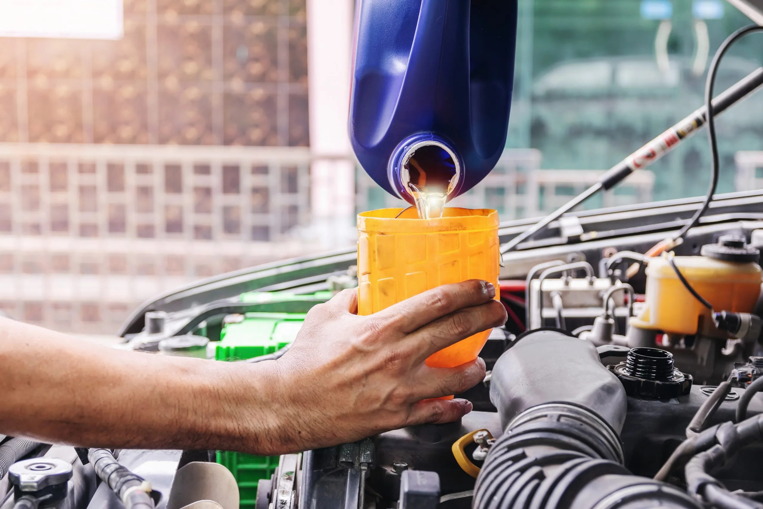 USA Transmission Fluids Market Outlook to 2035 auto-mechanic-is-filling-up-car-s-engine-oil-inside-auto-repair-center-scaled