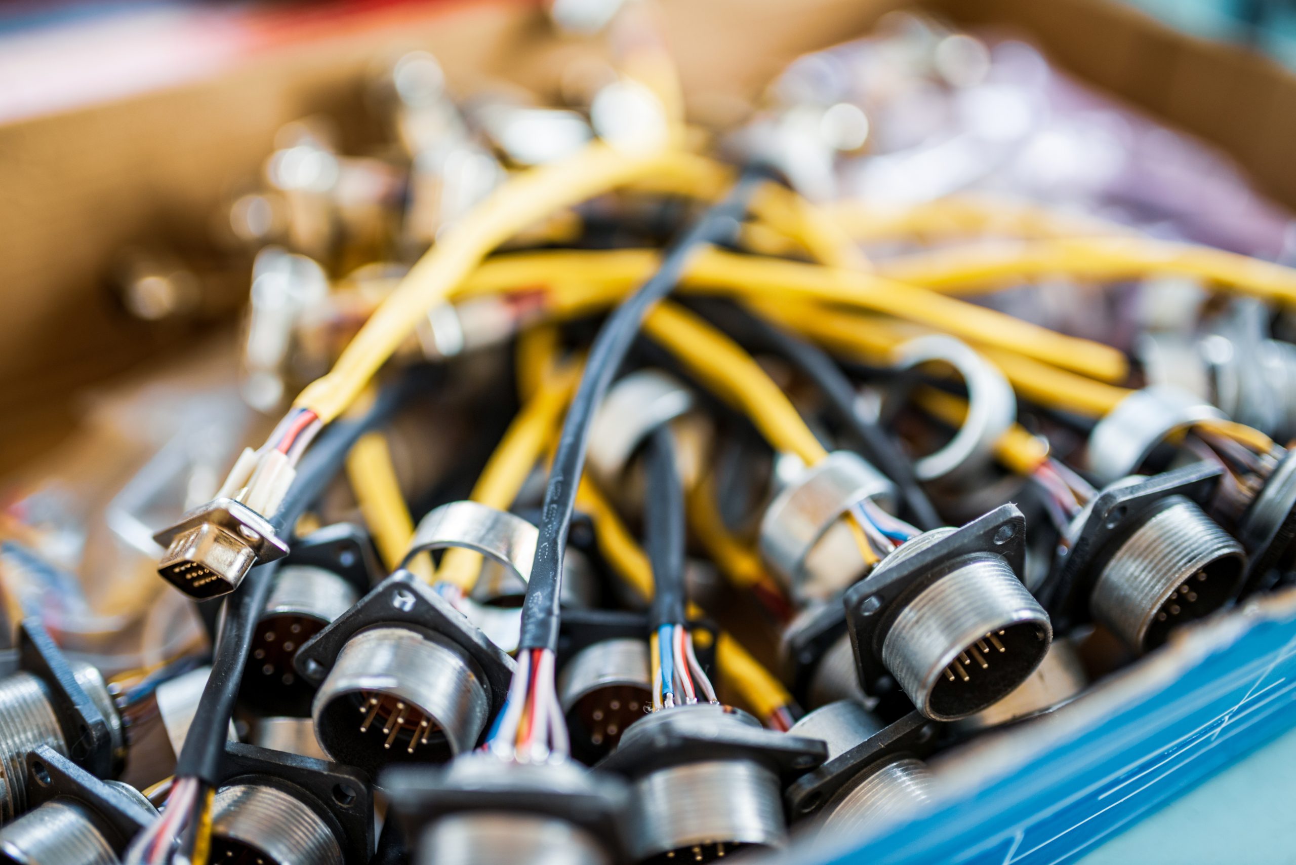 bunch-colorful-cables-with-plugs-tft-displays-connection-cardboard-crate-production-plant-workshop-extreme-close-view-scaled