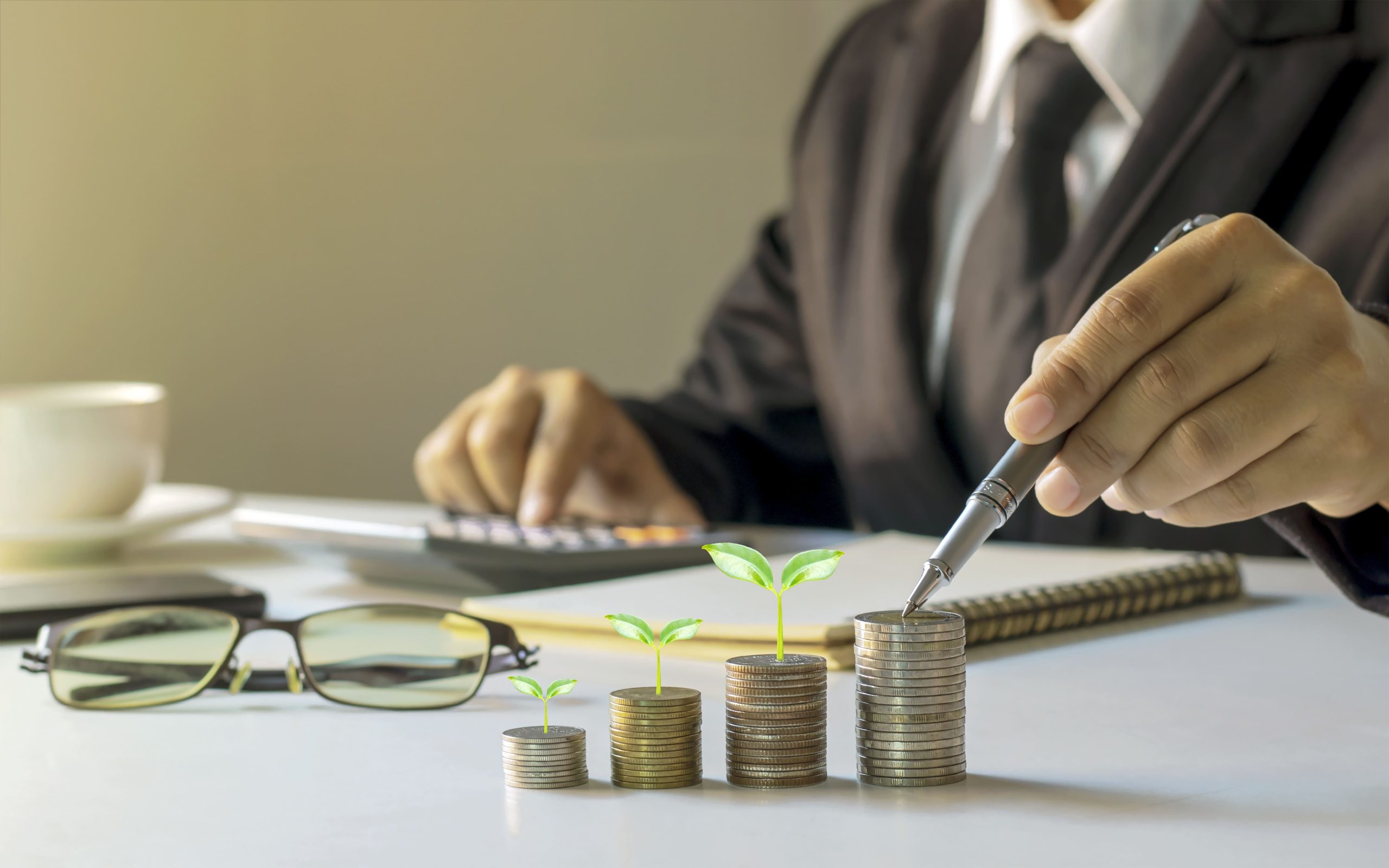businessman-holding-pen-tree-growing-coin-planning-ideas-investing-growing-money-1-scaled