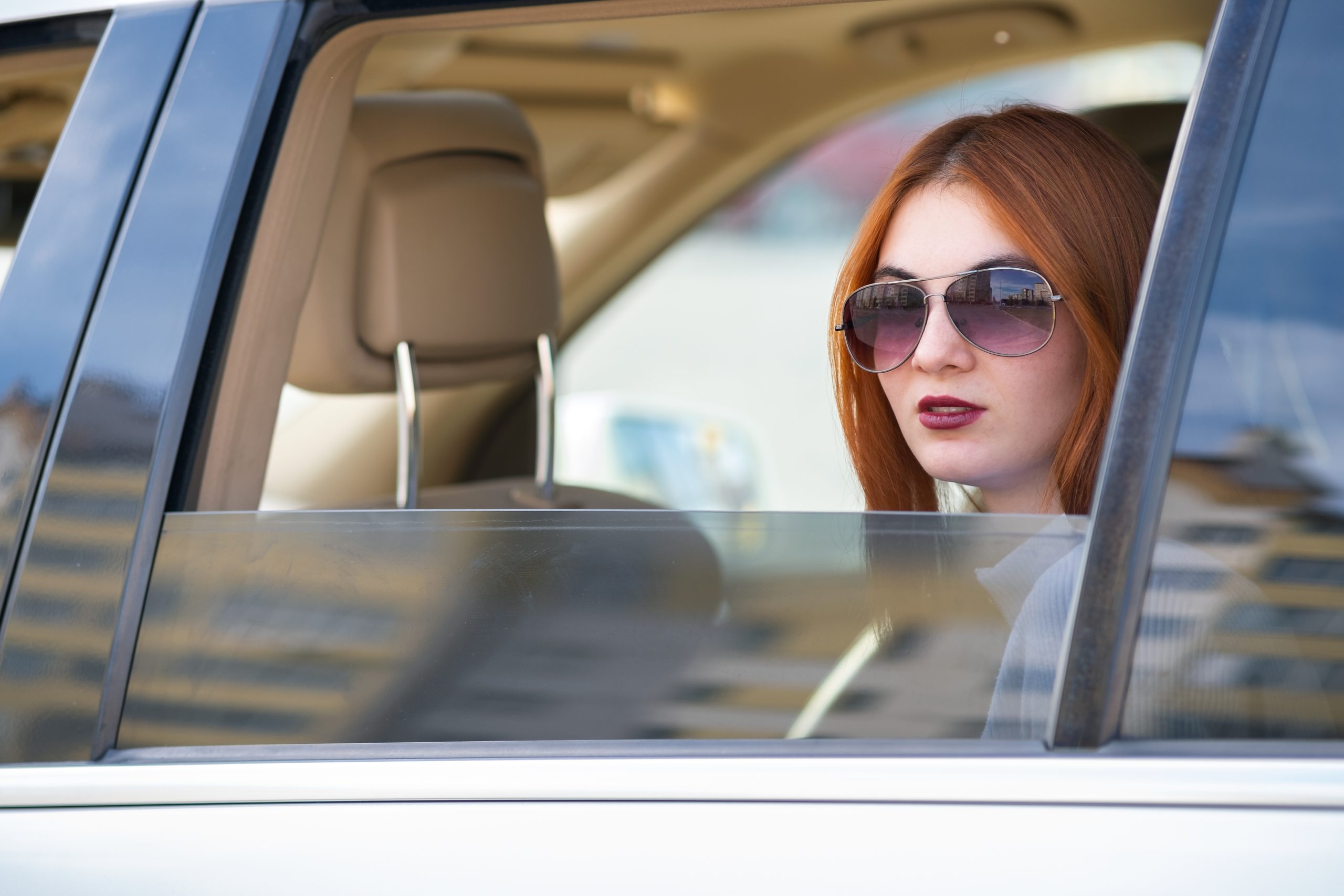 Philippines Automotive Sun Visors Market Outlook 2035 young-woman-with-red-hair-sun-glasses-travelling-by-car-scaled