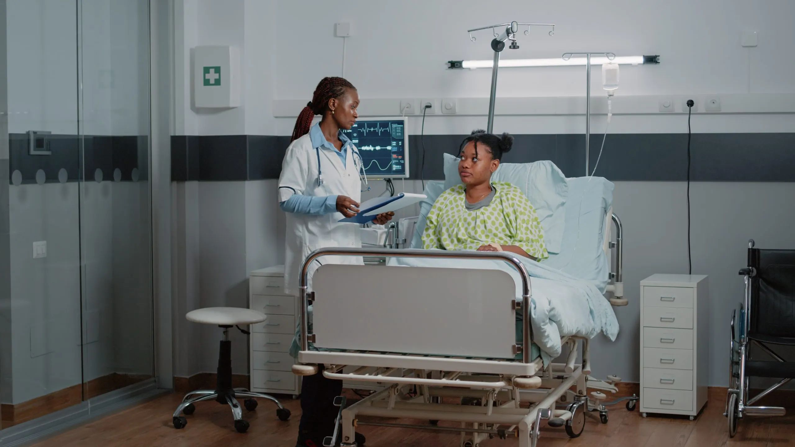 UAE Hospital Beds Equipment Market Outlook 2035 african-american-doctor-doing-consultation-with-patient-bed-while-medical-assistant-helping-with-oximeter-measure-oxygen-saturation-medic-consulting-person-with-iv-drip-bag-scaled