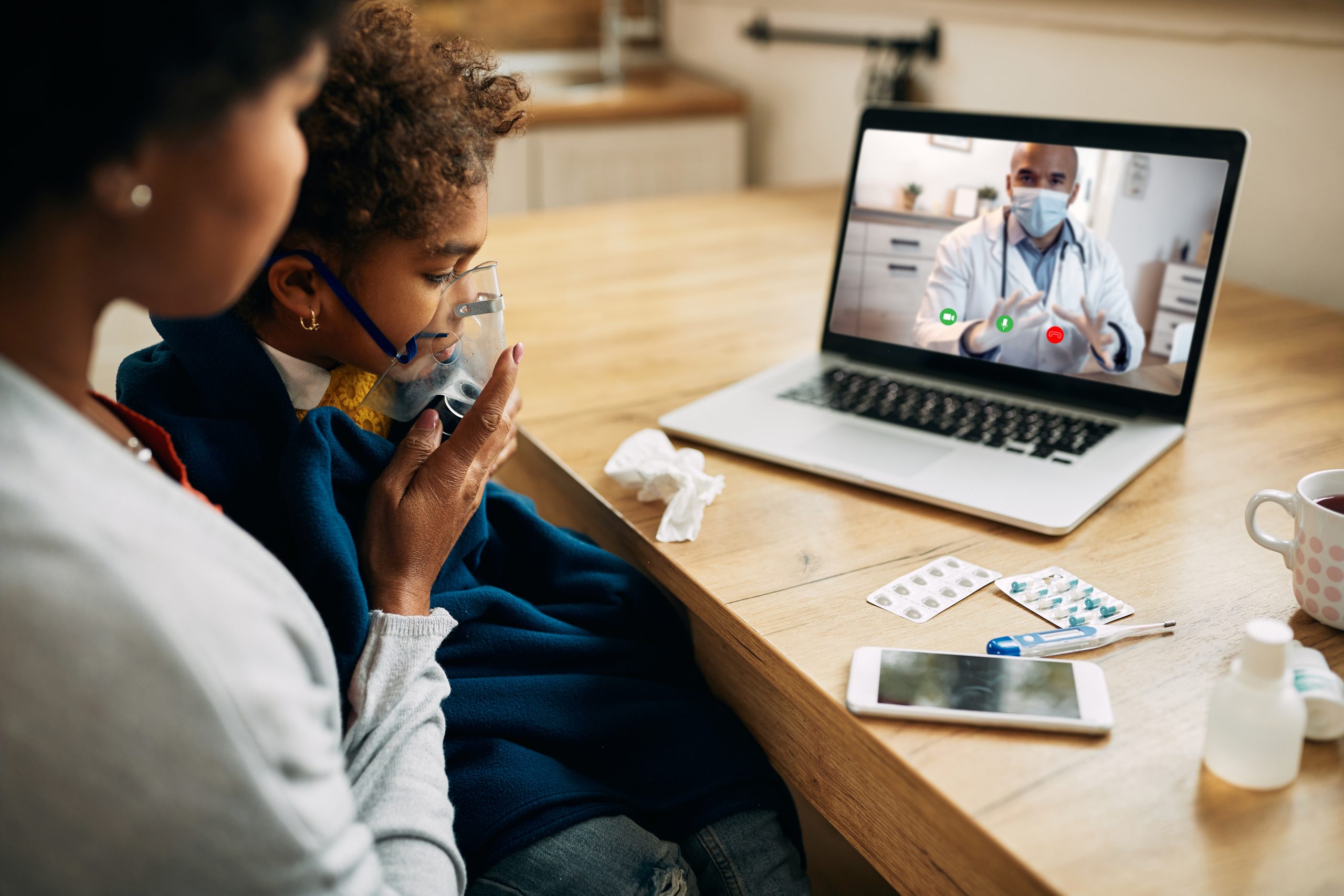 black-pediatrician-talking-via-video-call-mother-who-is-giving-her-daughter-inhaling-therapy-home-scaled