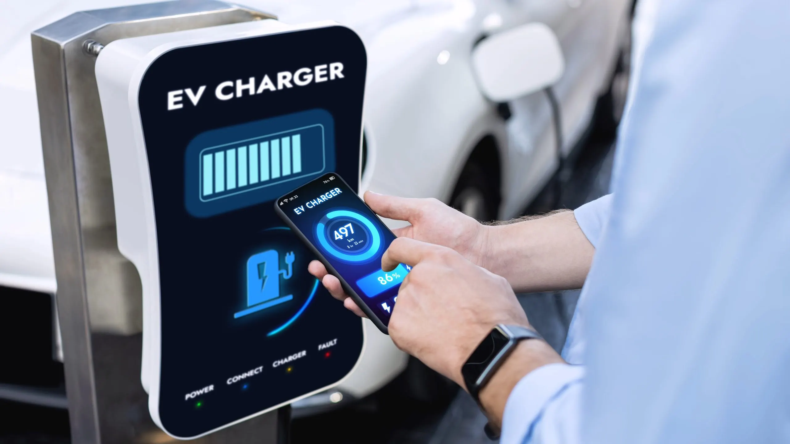 Saudi Arabia EV Battery Management System Market with 50,000 EVs and 15% Charging Stations Growth businessman-holding-smartphone-display-battery-status-interface-by-smart-ev-mobile-application-while-ev-car-recharging-electricity-from-charging-station-car-park-peruse-scaled