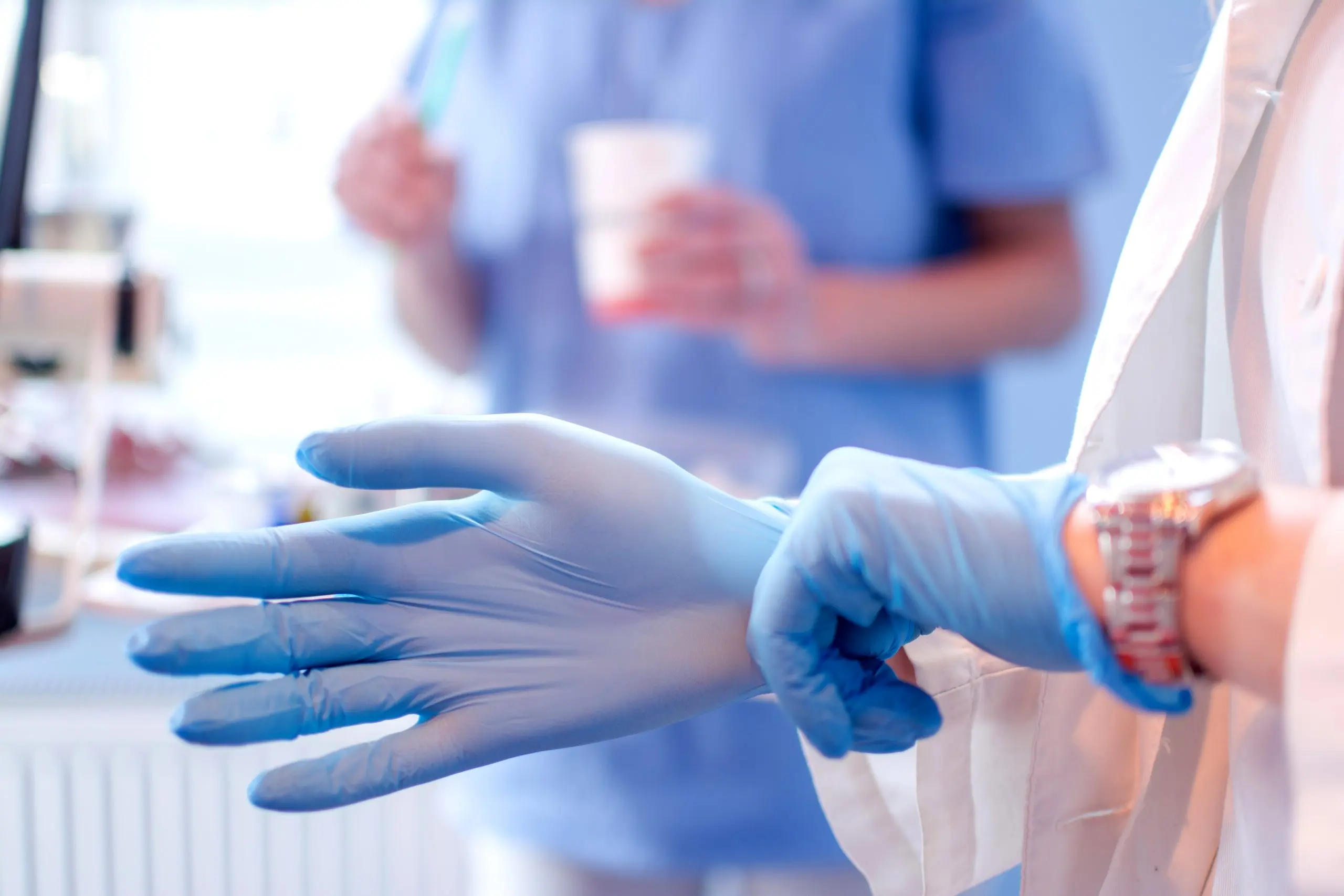 UAE Medical Gloves Market Outlook 2035 close-up-female-doctors-hands-putting-blue-sterilized-surgical-gloves-medical-clinic-scaled