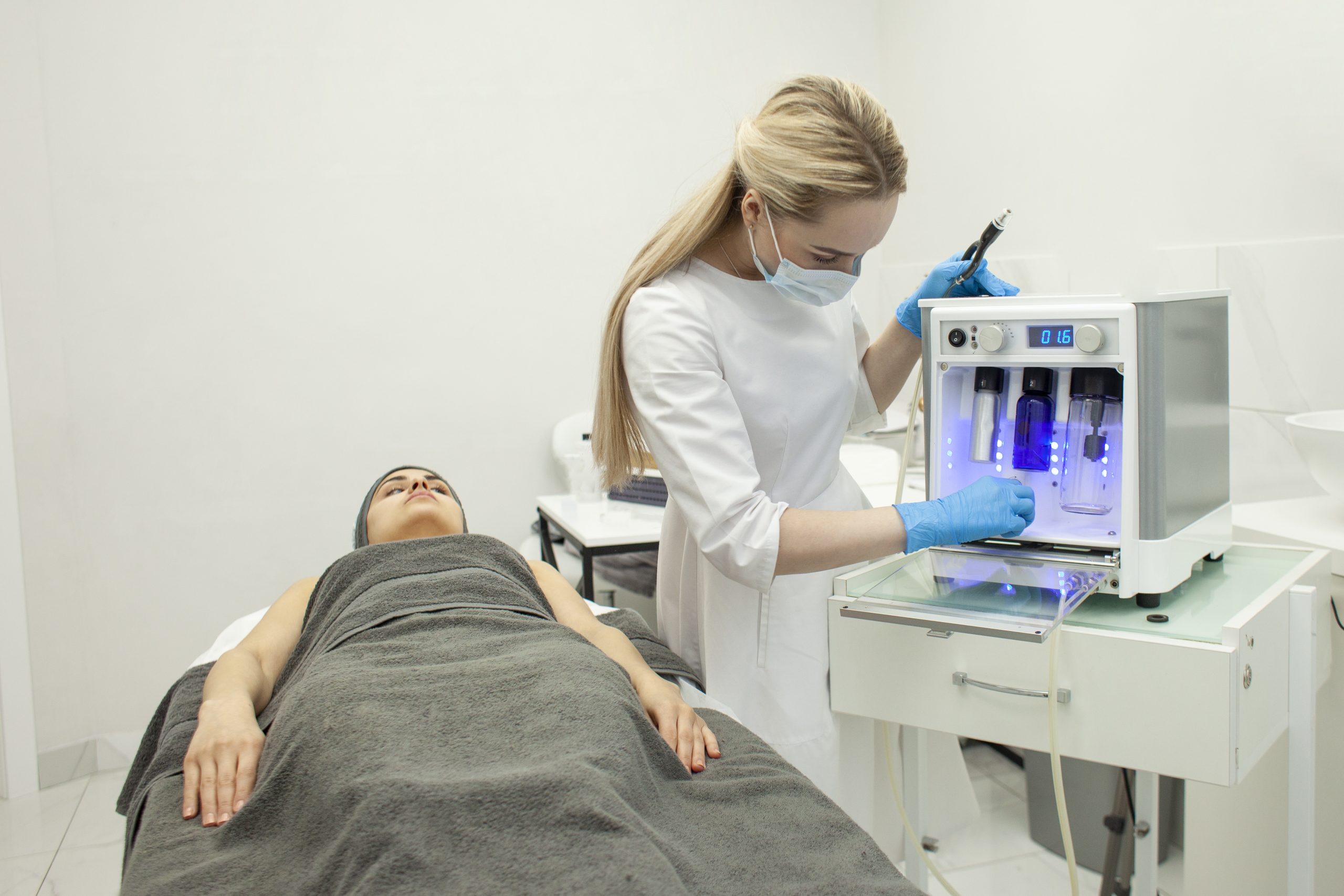 cosmetologist-clinic-sets-up-modern-equipment-dermatologist-doctor-sets-up-device-vacuum-scaled