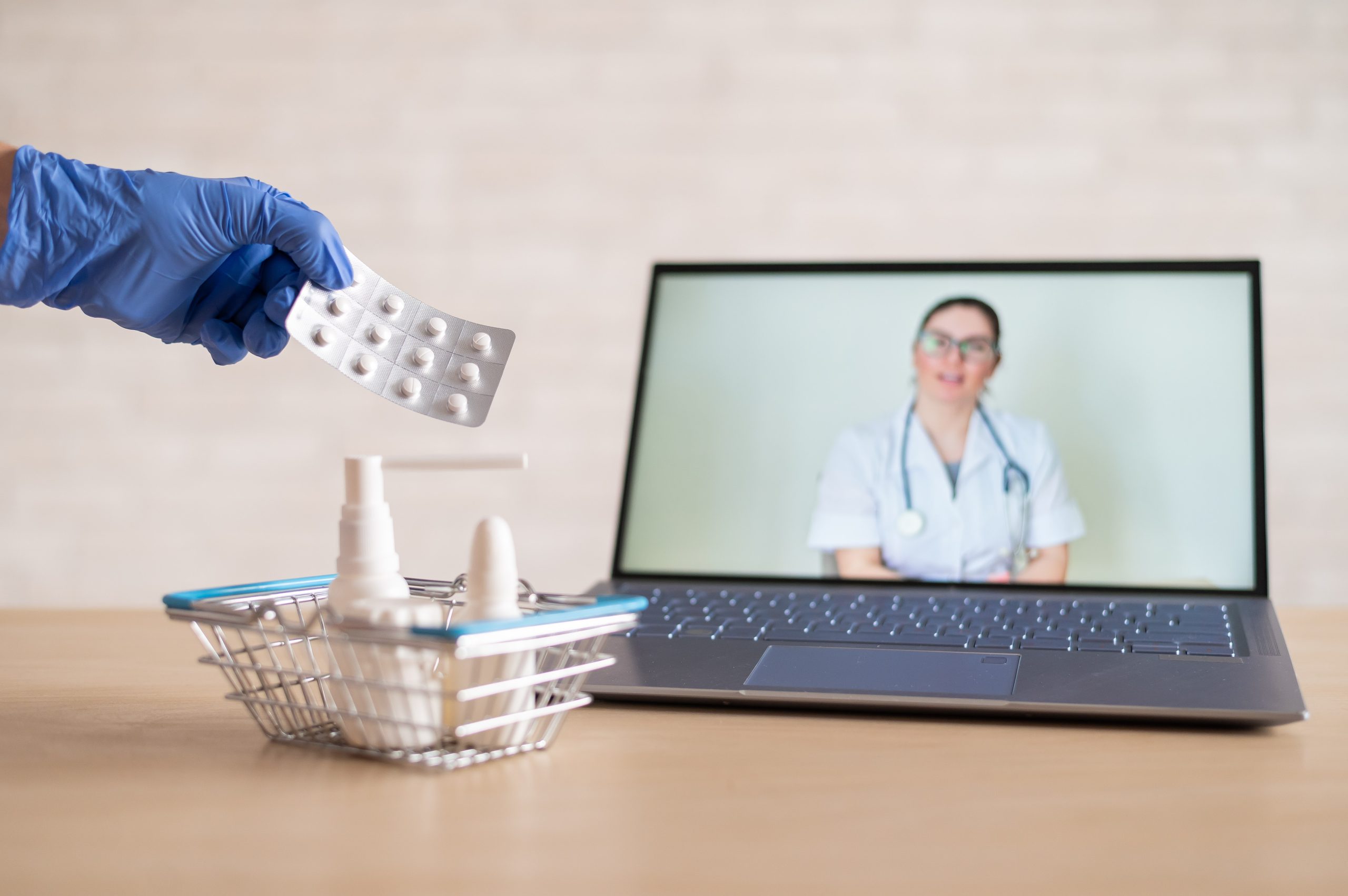 friendly-doctor-conducts-online-consultation-laptop-gloved-pharmacist-puts-medicine-into-mini-shopping-cart-concept-distance-medicine-order-drugs-online-scaled