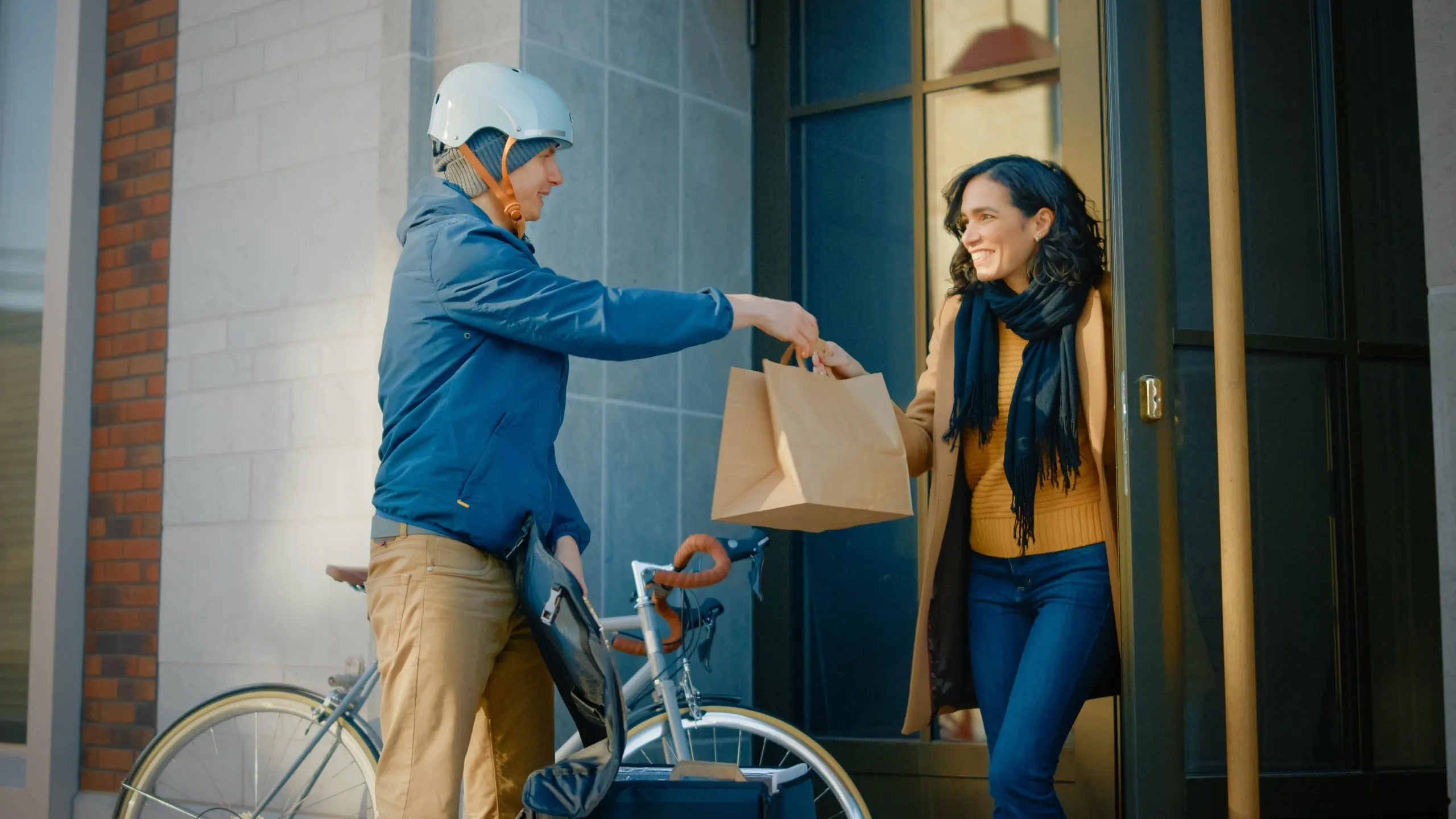 The Future of USA Last-Mile Delivery E-Commerce Technology and Sustainability Leading the Way with $60 Billion Market value man-wearing-helmet-is-handing-bag-food-woman-outside-building-scaled