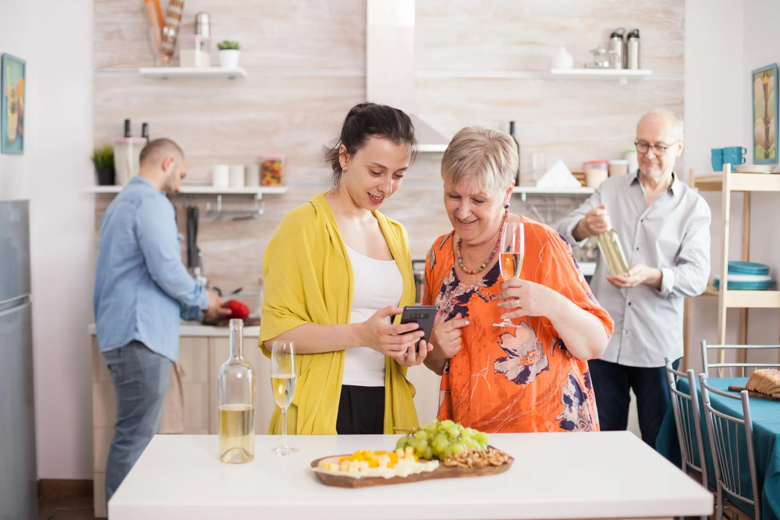 India Home Care Market Outlook to 2035 mother-daughter-browsing-smartphone-kitchen-family-brunch-senior-woman-holding-glass-white-wine-tasty-appetizer-scaled