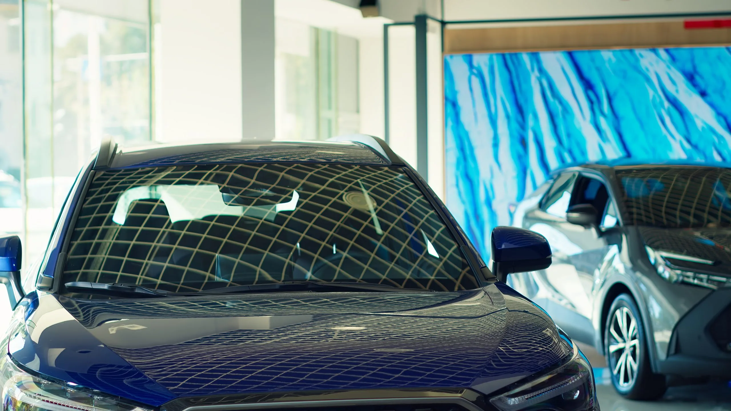 Exploring the USA Grilles Market Outlook, with key trends, innovations, and projected growth to $8 billion in the coming years panning-shot-cars-with-sleek-design-showroom-waiting-be-purchased-1-scaled