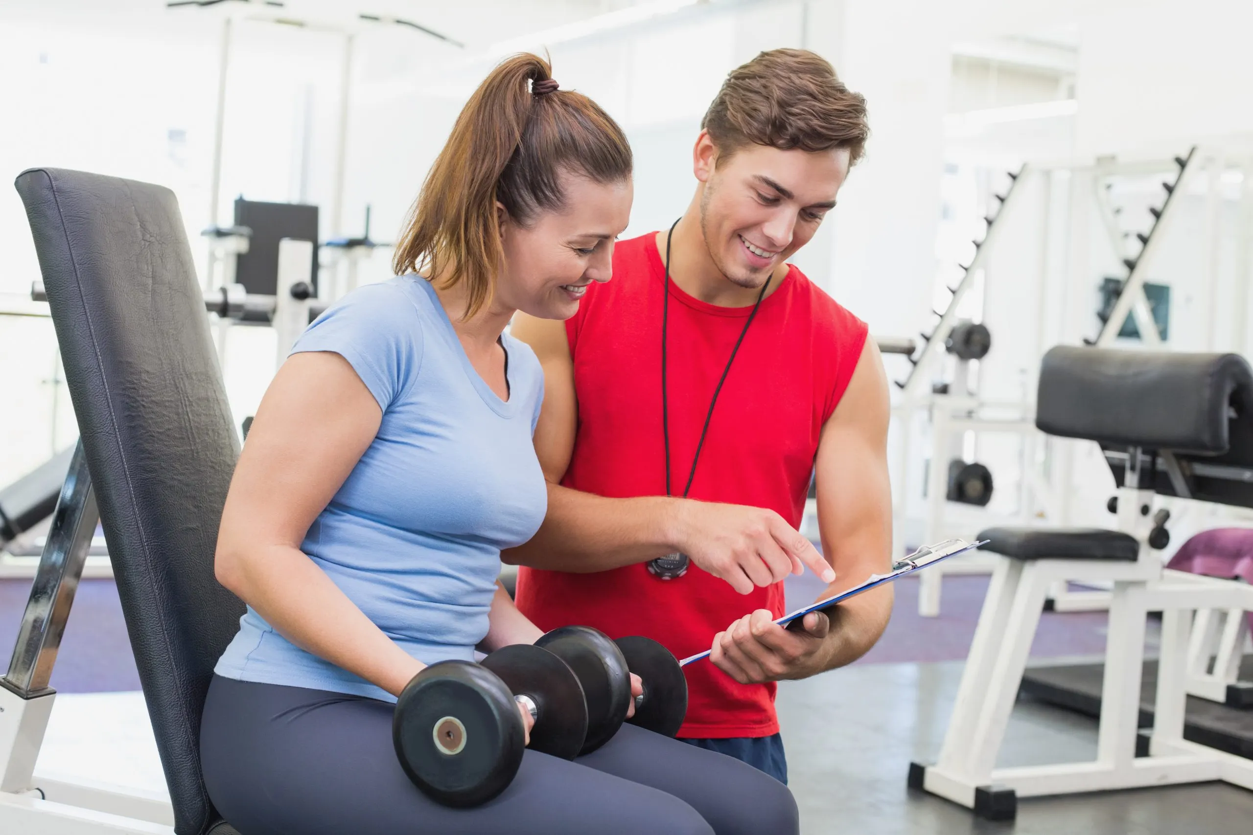 Nigeria health and fitness services Market Outlook to 2035 personal-trainer-working-with-client-holding-dumbbell-scaled