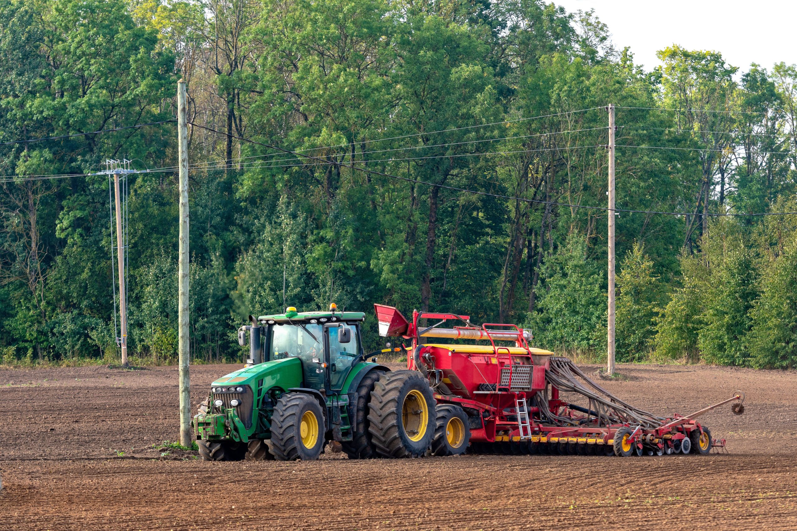 tractor-field-against-trees-forest-scaled