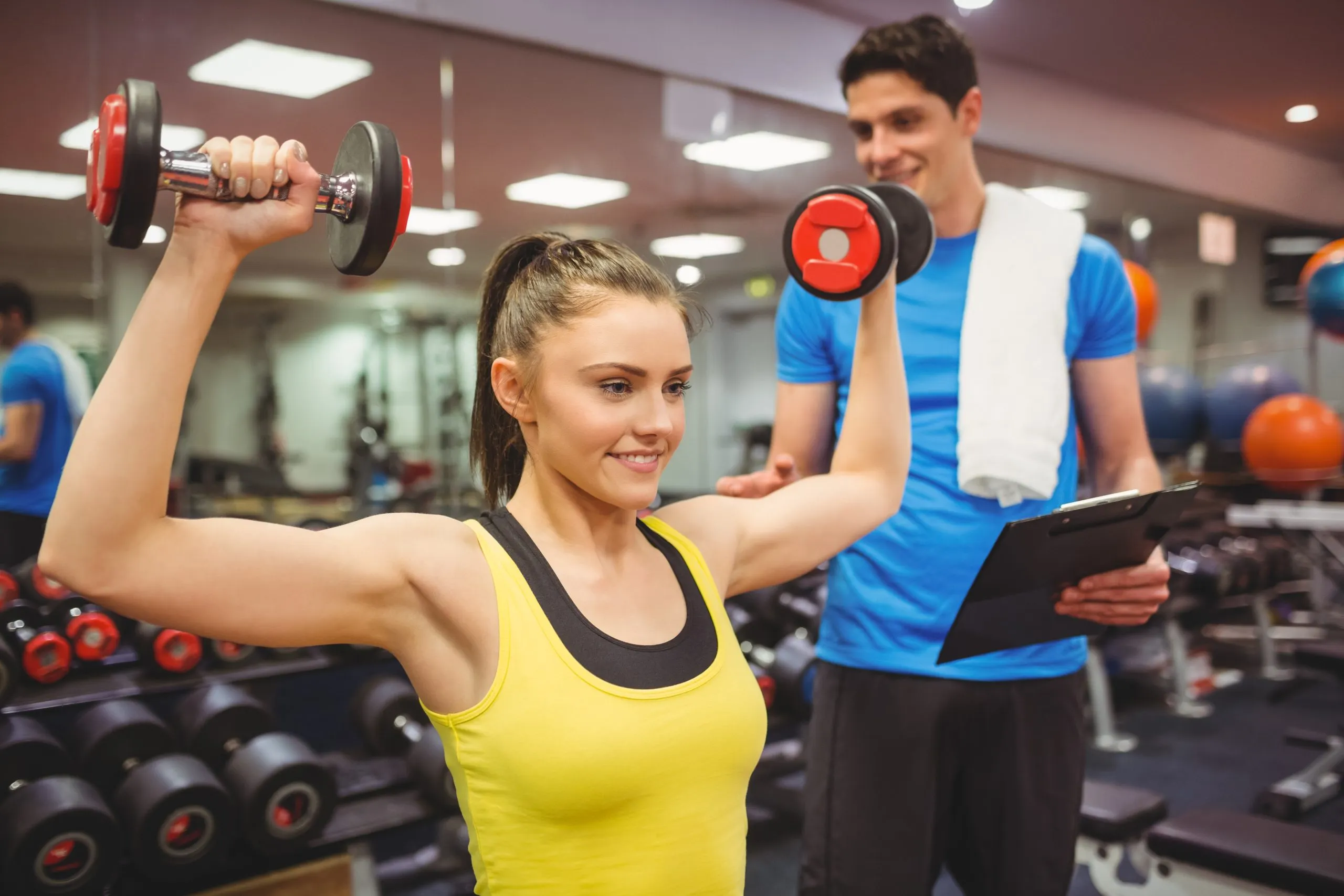 Singapore health and fitness services Market Outlook to 2035 woman-lifting-dumbbells-with-her-trainer-scaled