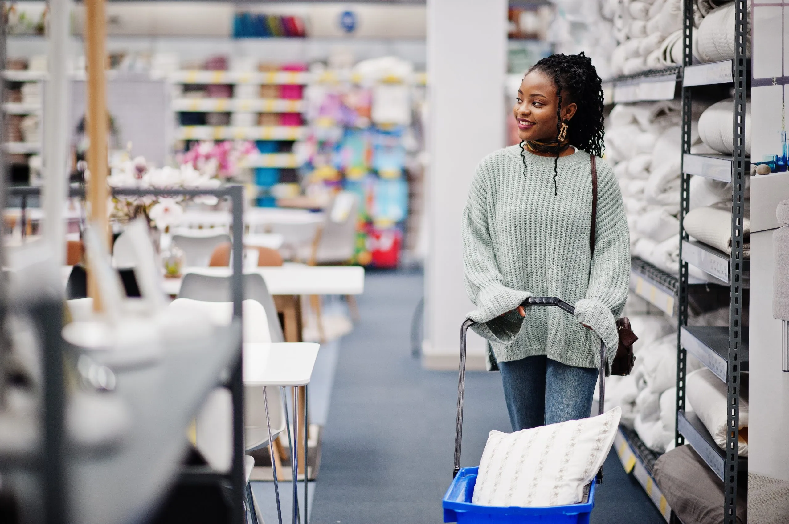 South Africa Adult Diaper Market Outlook to 2035 african-woman-walking-with-shopping-basket-modern-home-furnishings-store-scaled