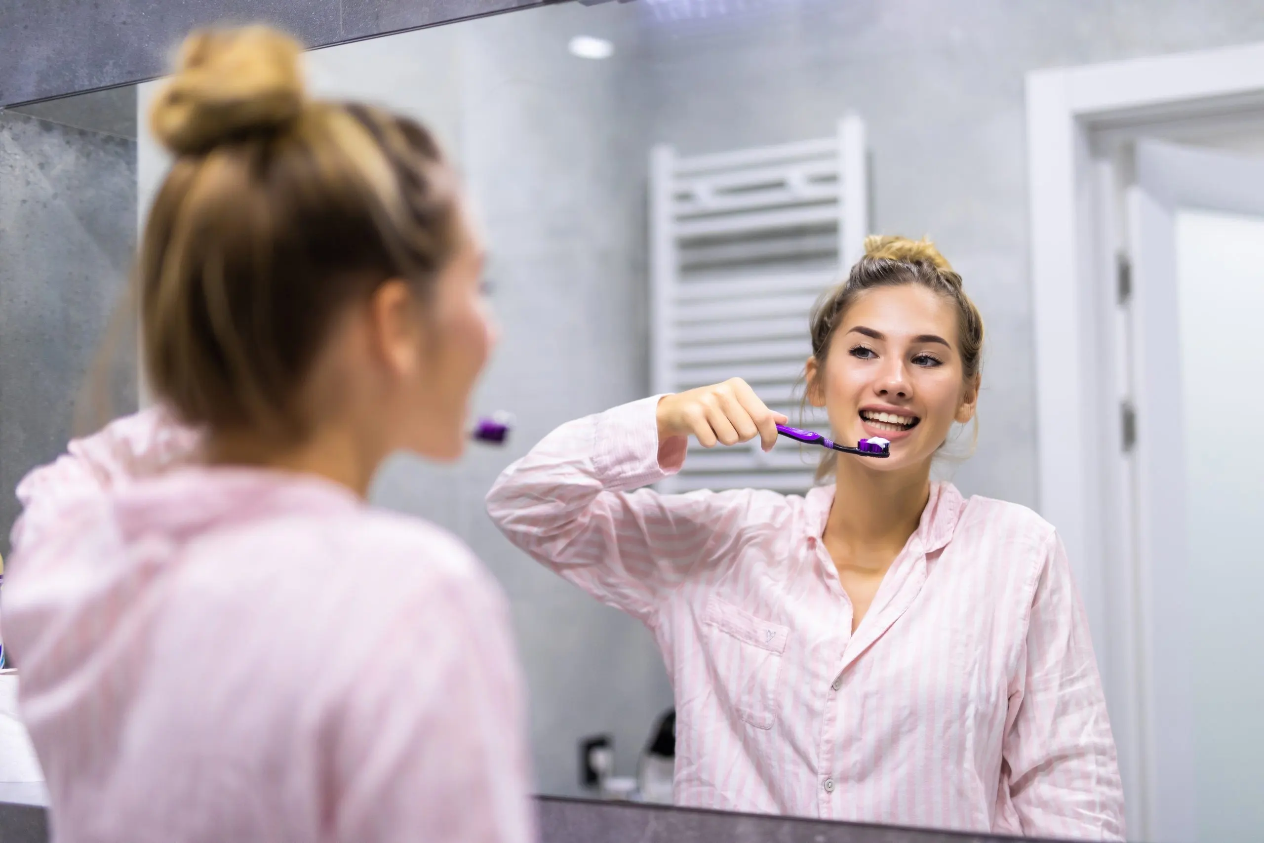 Singapore Oral Care Market Outlook to 2035 beautiful-young-woman-brushing-teeth-front-her-bathroom-mirror-selective-focus-scaled