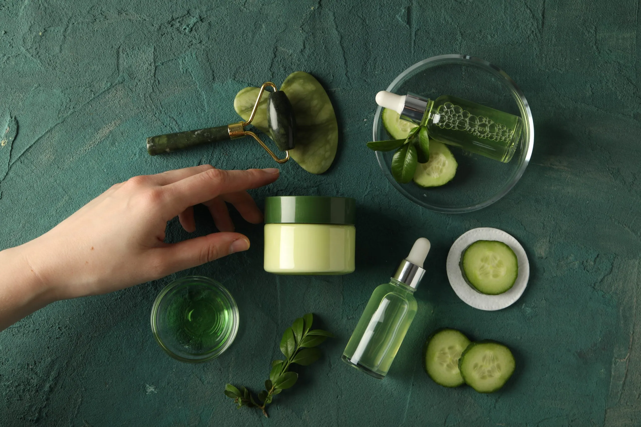 UAE Vegan Cosmetics Market Outlook Trends Innovations and Consumer Adoption Highlighting 18 % Growth in Plant-Based Product Adoption bottles-with-cosmetics-sliced-cucumber-facial-massagers-female-hand-green-background-scaled