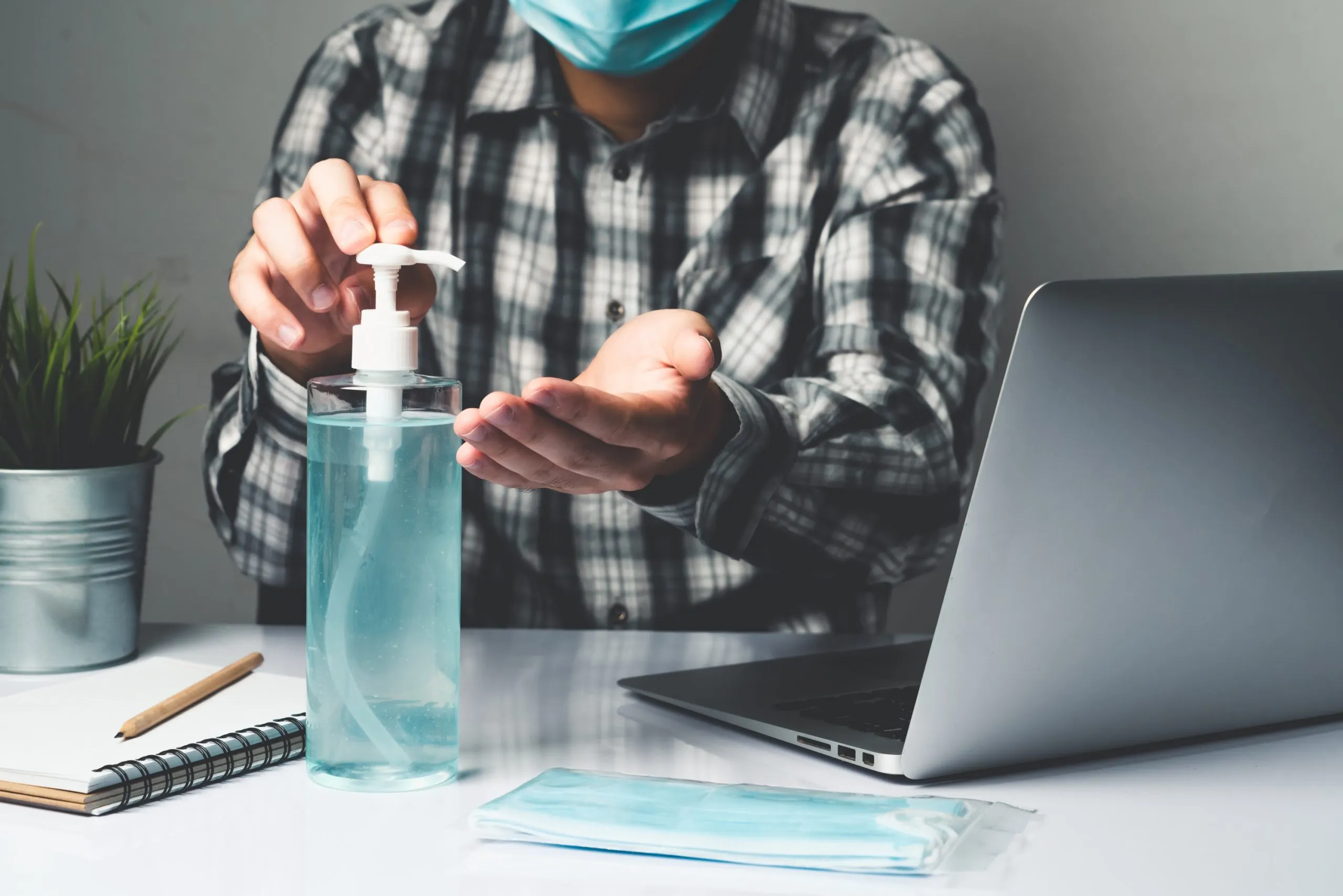 Nigeria Hand Sanitizer Market Outlook to 2035 coronavirus-disease-covid-19-protection-concept-young-man-work-office-room-home-with-protective-cleaning-equipment-protect-against-corona-virus-while-using-laptop-computer-desk-scaled