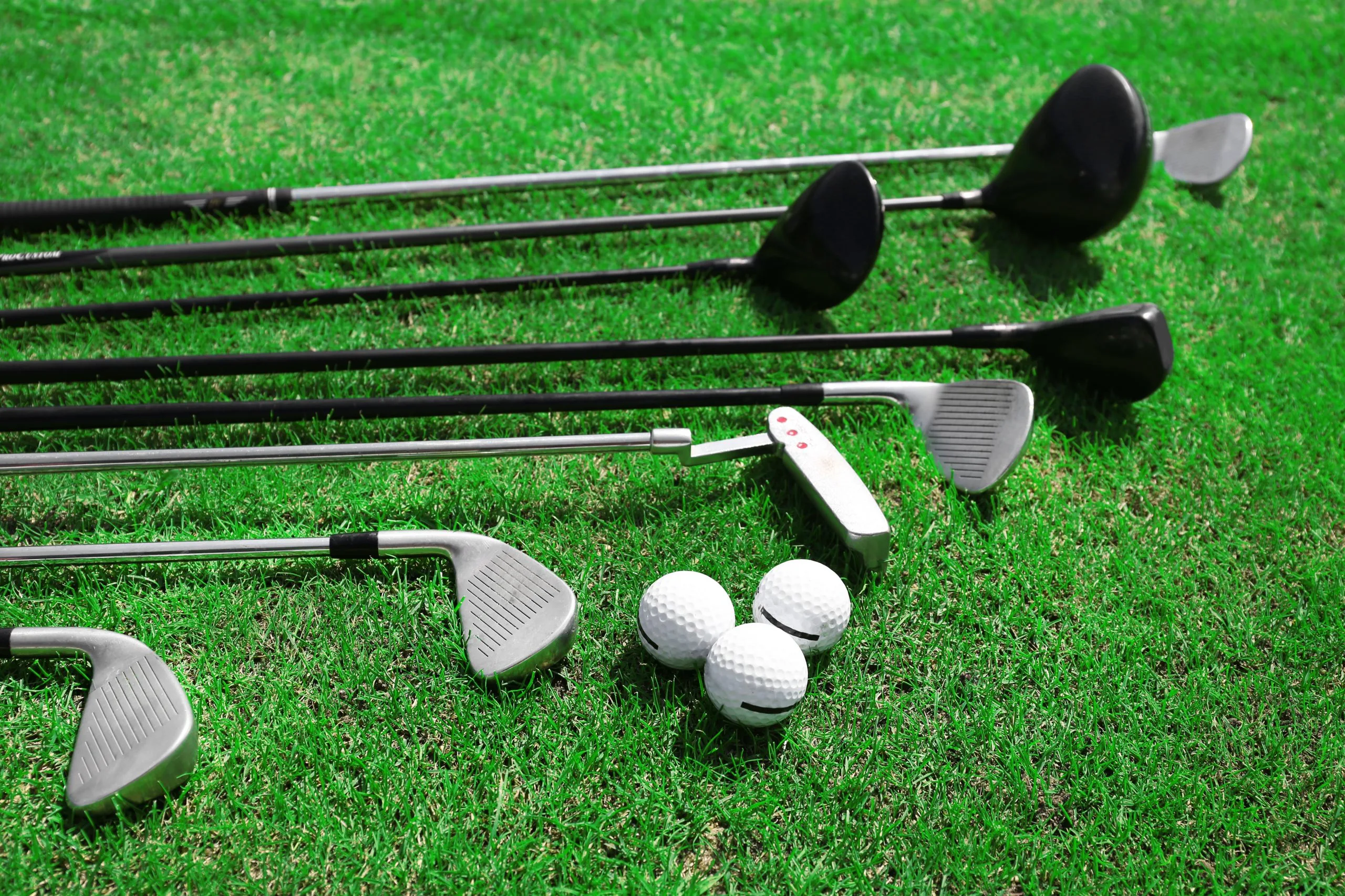 UK Golf Equipment Market Outlook to 2035 different-golf-clubs-row-balls-green-grass-scaled