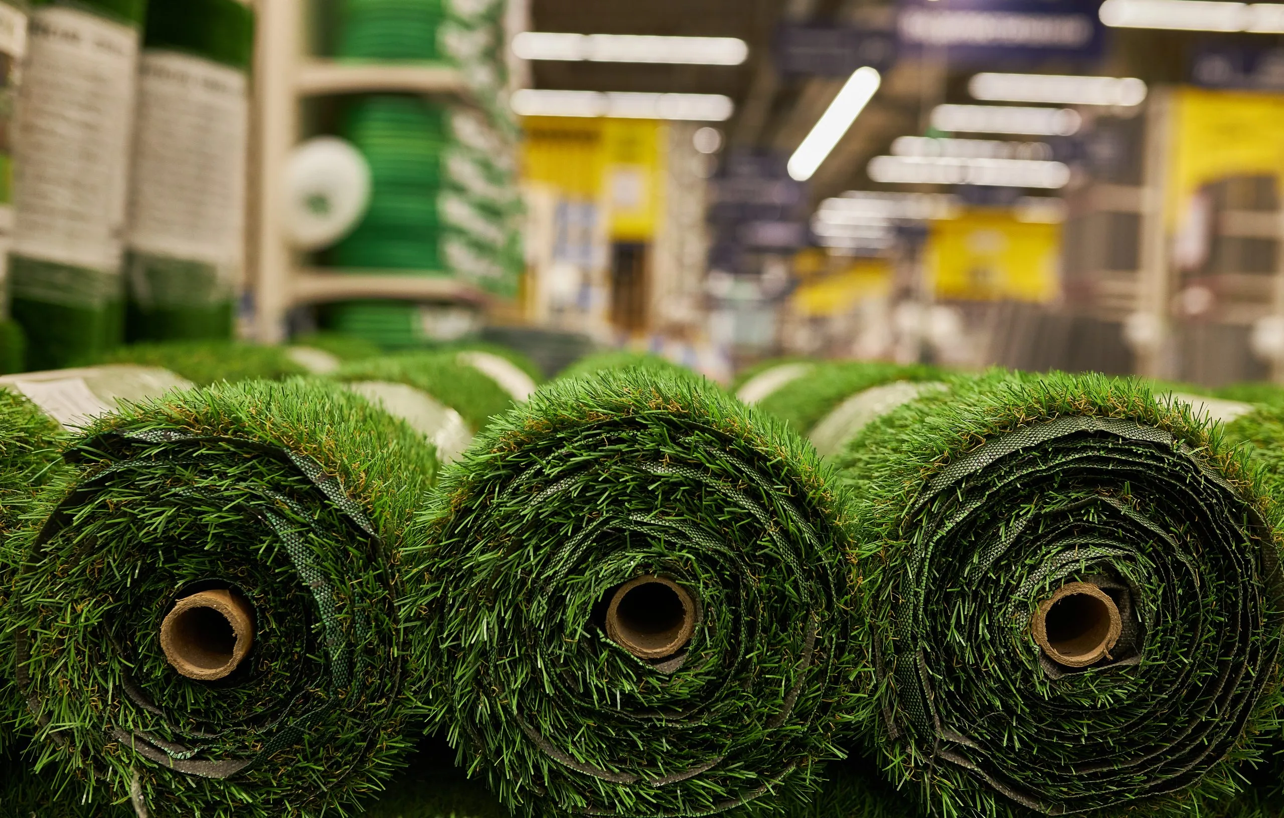 India Artificial Turf Market Outlook to 2035 green-artificial-grass-rolls-close-up-rolls-artificial-grass-store-building-materials-scaled