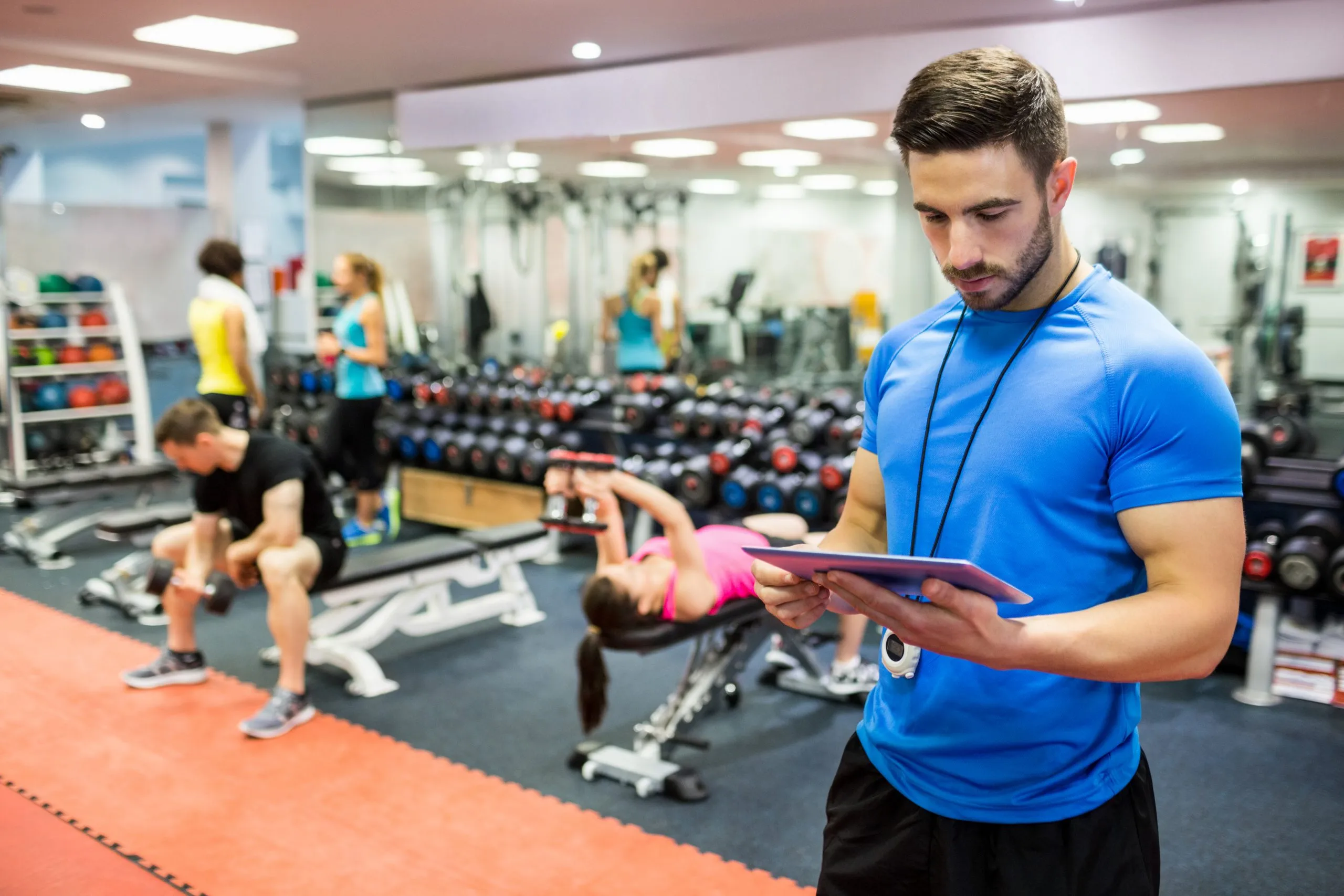 South Africa Health and Fitness Club Market Outlook to 2035 handsome-trainer-using-tablet-weights-room-scaled