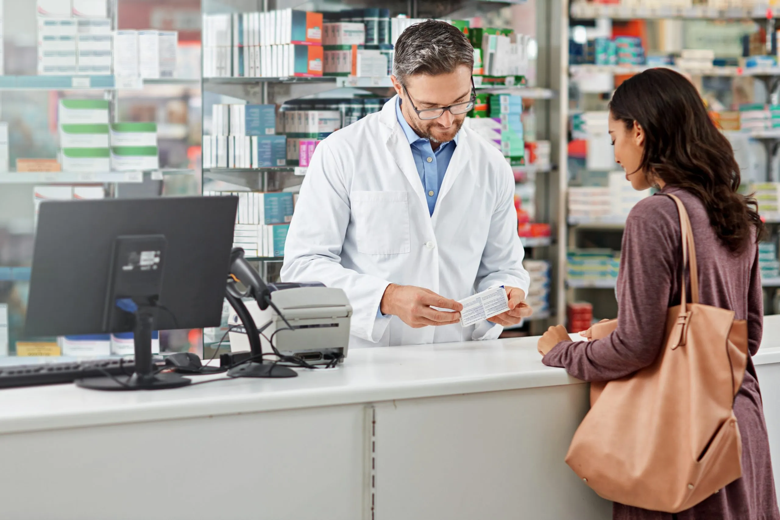 The Future of Pharmacy Retail in Qatar Highlighting 20 % Rise in E-Pharmacy Adoption and Digital Transformation medicine-service-help-pharmacist-consulting-health-store-counter-with-expert-knowledge-medication-advice-trust-girl-with-kind-worker-checking-information-pharmacy-scaled