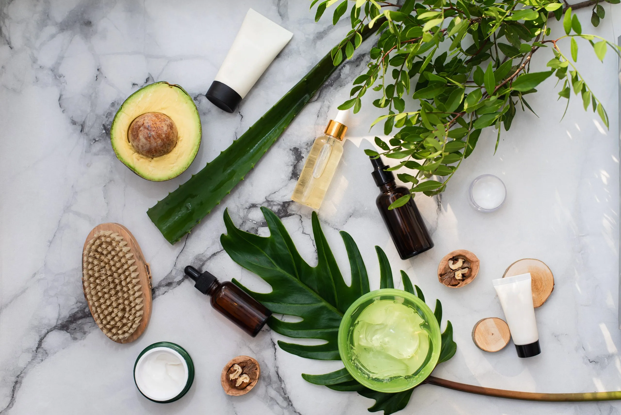 USA Vegan Cosmetics Market Trends and Growth Opportunities With 12 % CAGR and Rising Consumer Demand natural-cosmetics-with-herbal-ingredients-flat-lay-bottles-essential-oils-jar-moisturizer-green-leaves-white-stone-marble-background-scaled