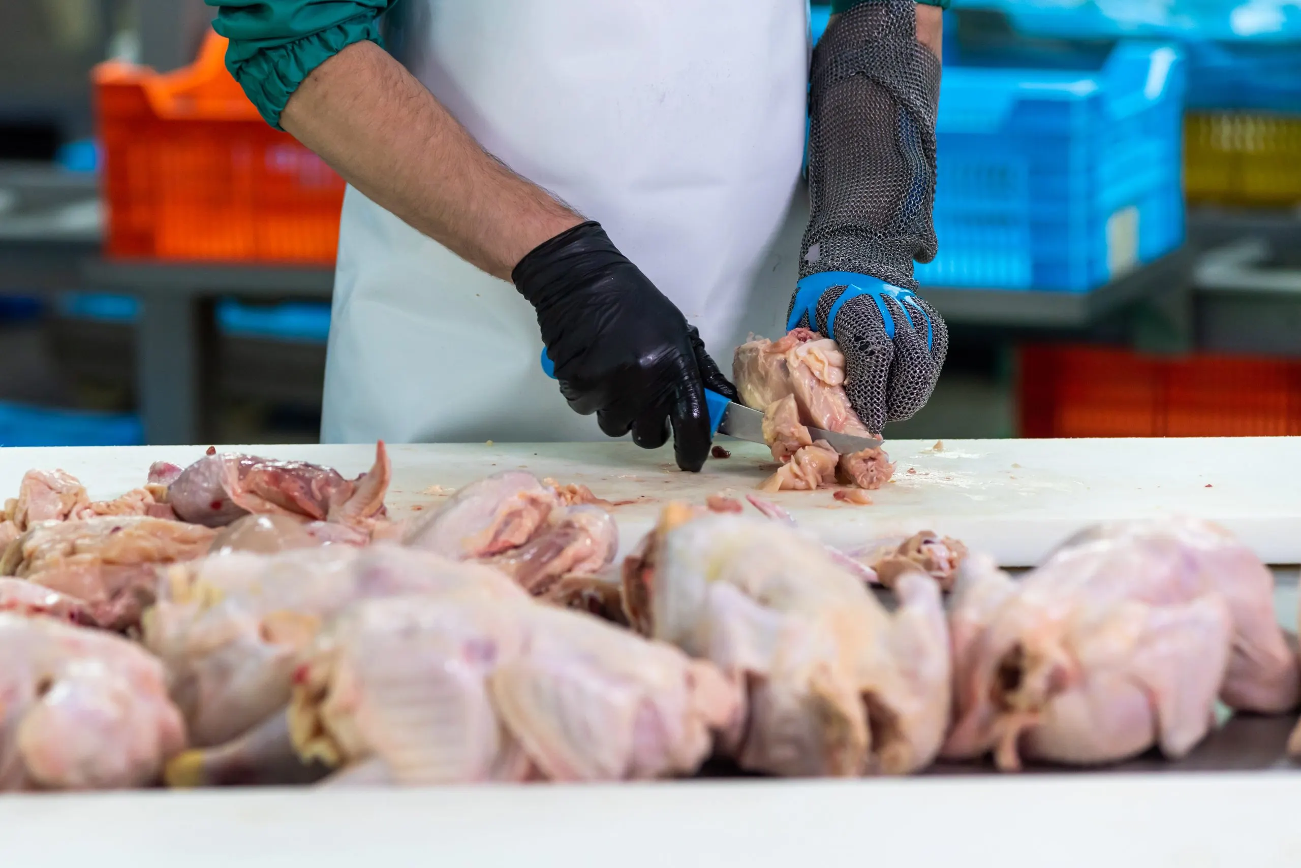 UK Poultry Meat Market Outlook to 2035 person-chopping-chicken-counter-scaled