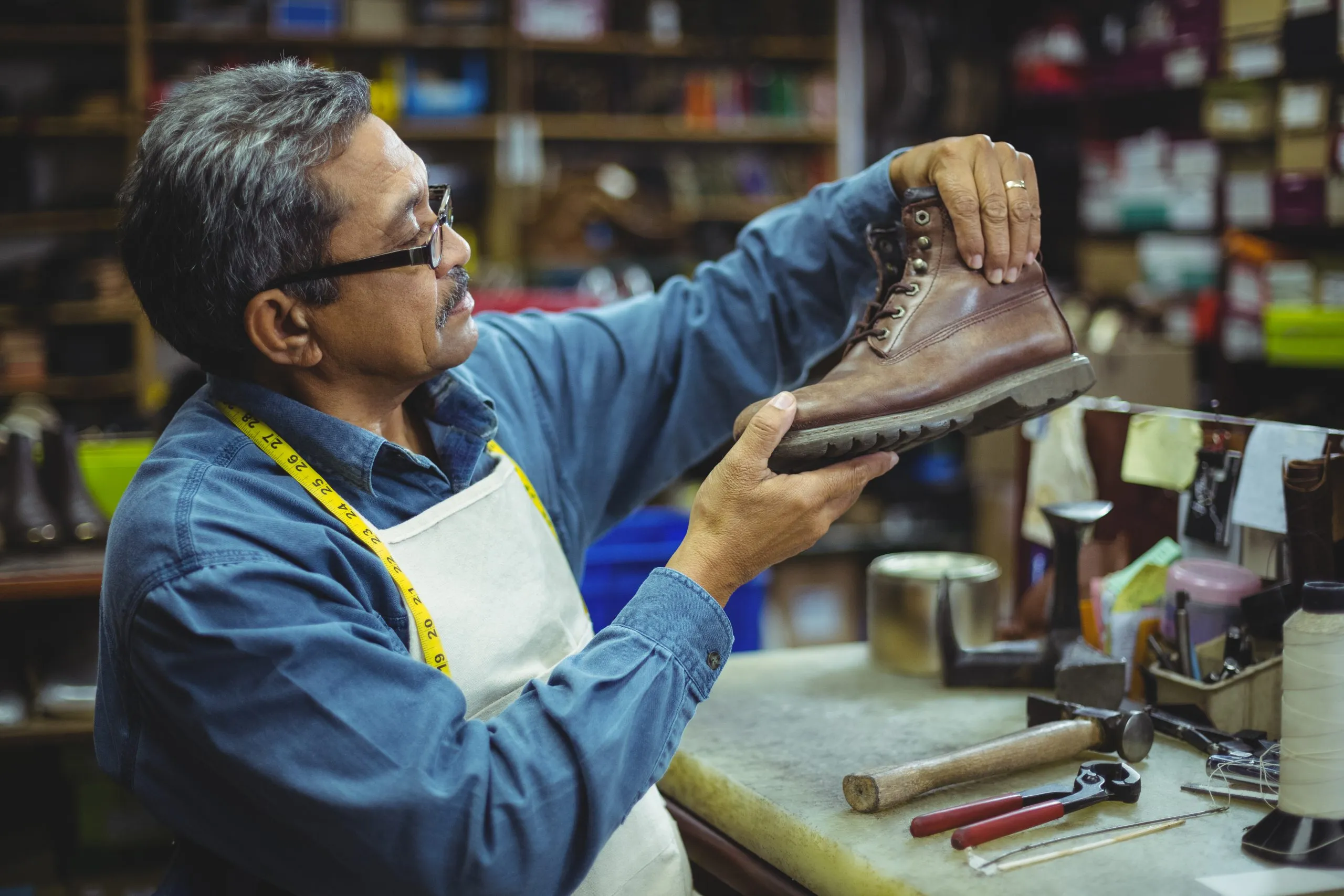 Singapore Industrial Protective Footwear Market Outlook to 2035 shoemaker-examining-shoe-scaled