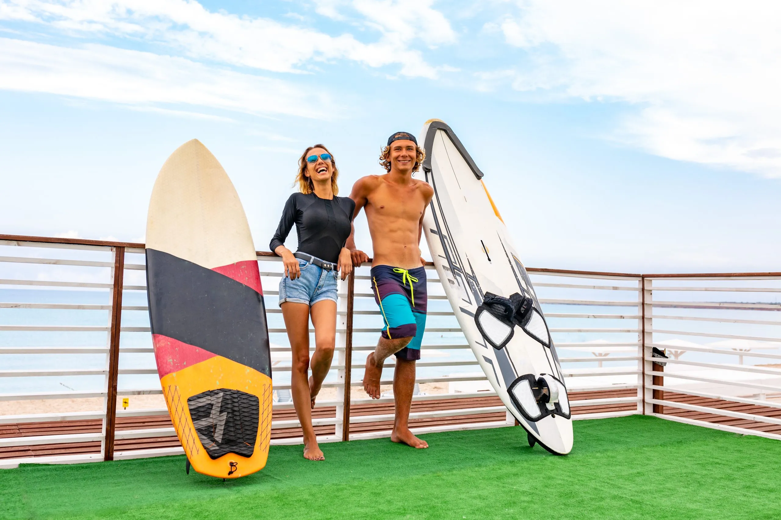 Vietnam Surfing Equipment Market Outlook to 2035 smiling-young-active-couple-surfers-relaxing-beach-after-sport-with-surfboard-healthy-lifestyle-extreme-water-sports-scaled