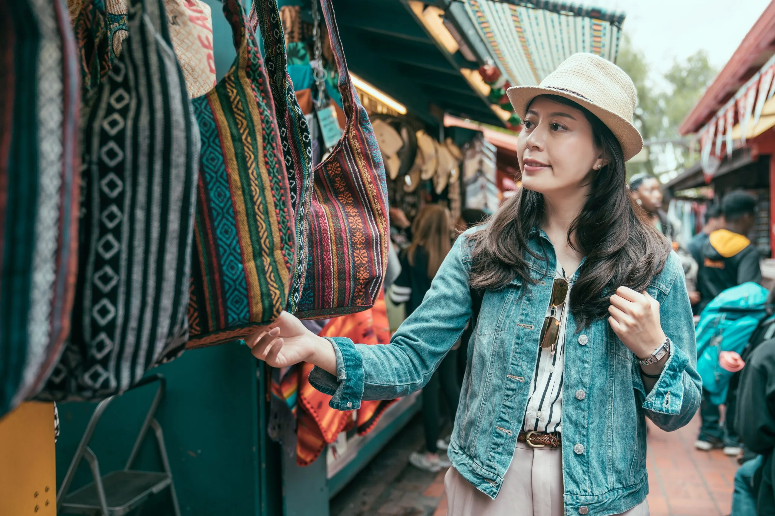 Vietnam Outdoor Apparel Market Outlook to 2035 summer-holidays-shopping-concept-young-asian-woman-tourist-buying-souvenirs-gift-olvera-street-stall-outdoor-picking-choosing-bags-vendor-girl-traveler-shopping-mexico-market-sunny-day-scaled