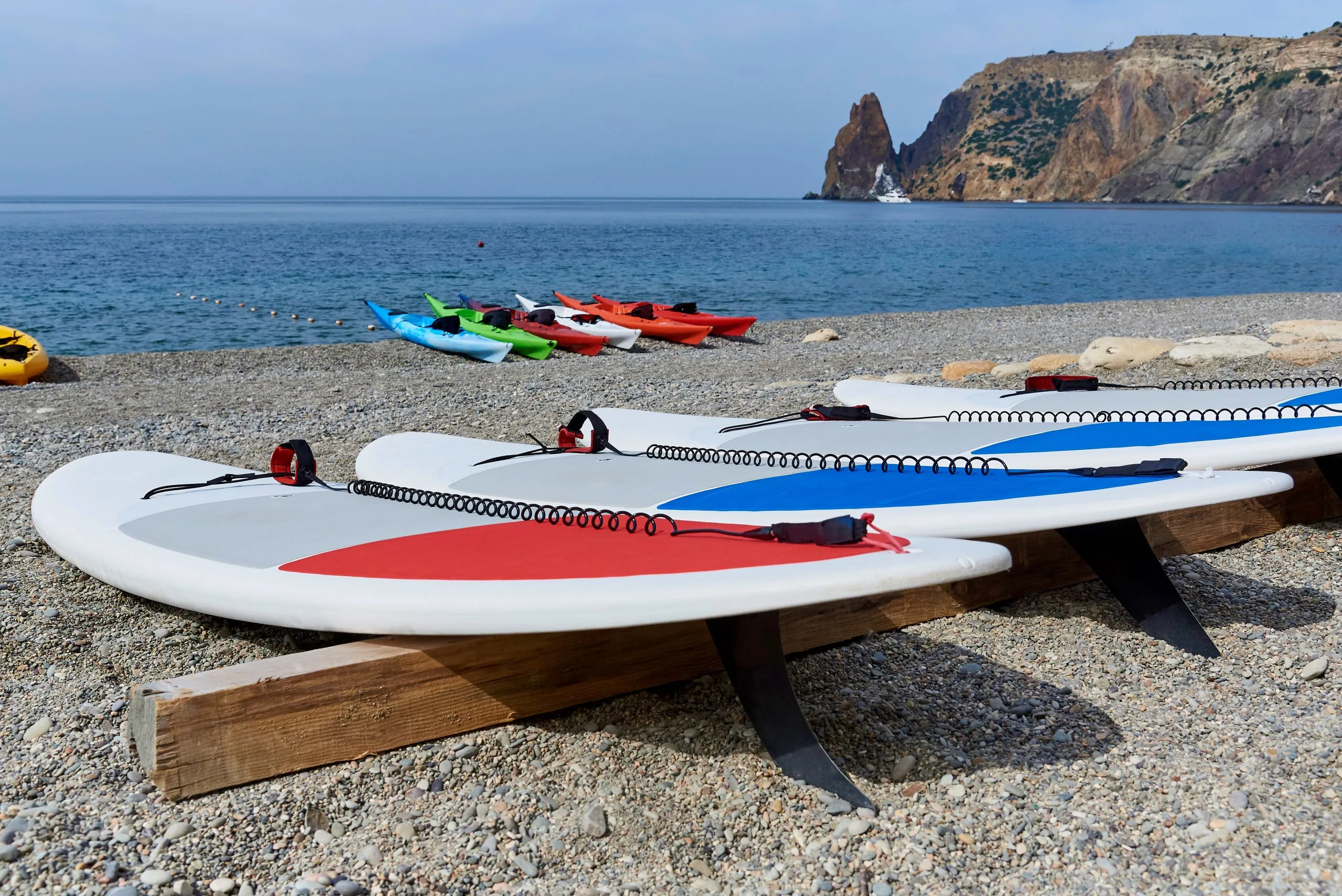 KSA Surfing Equipment Market Outlook to 2035 surfboards-coast-with-kayaks-background-sea-rocks-scaled