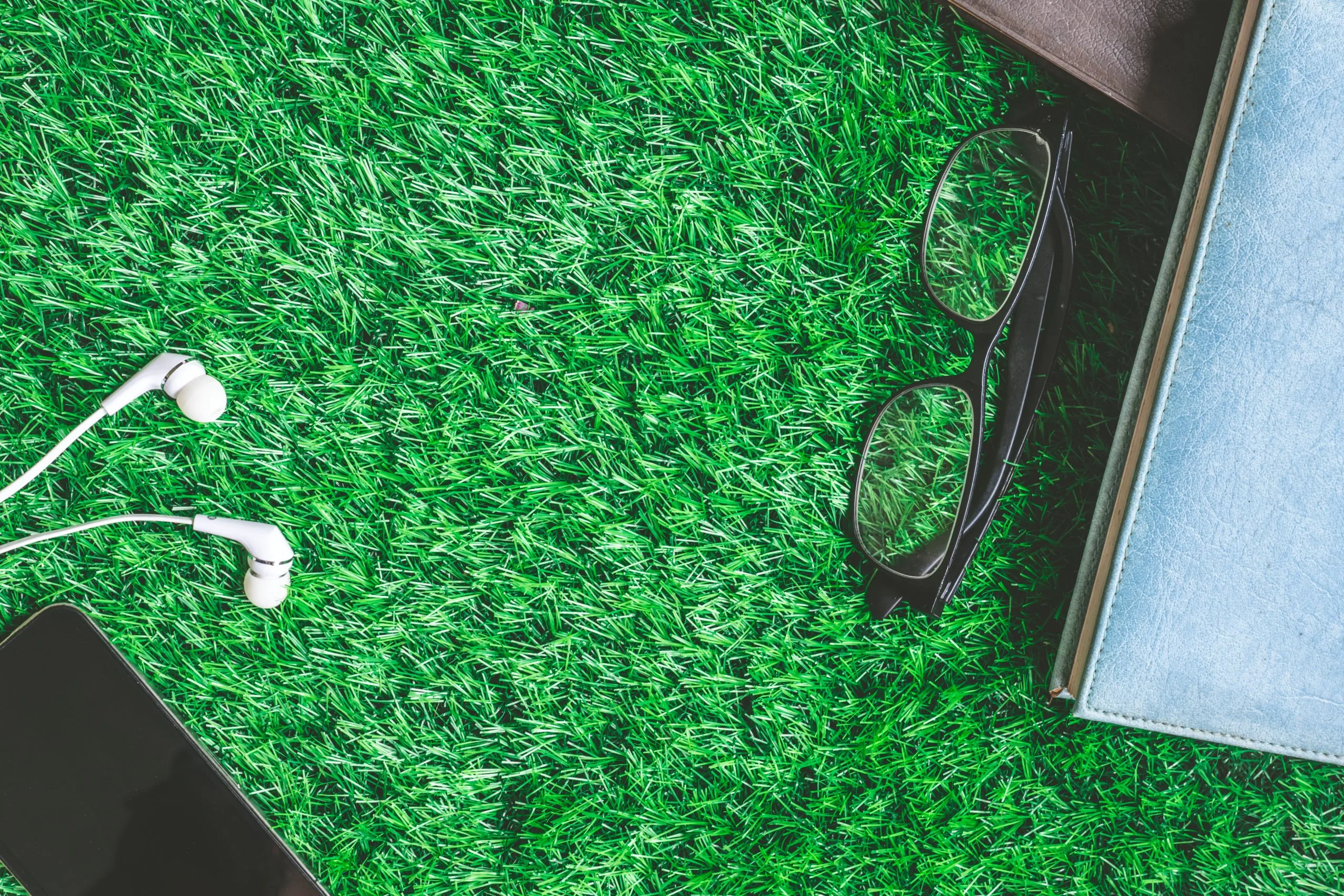 Vietnam Artificial Turf Market Outlook to 2035 top-view-books-with-glasses-smart-phone-earphones-green-grass-background-scaled