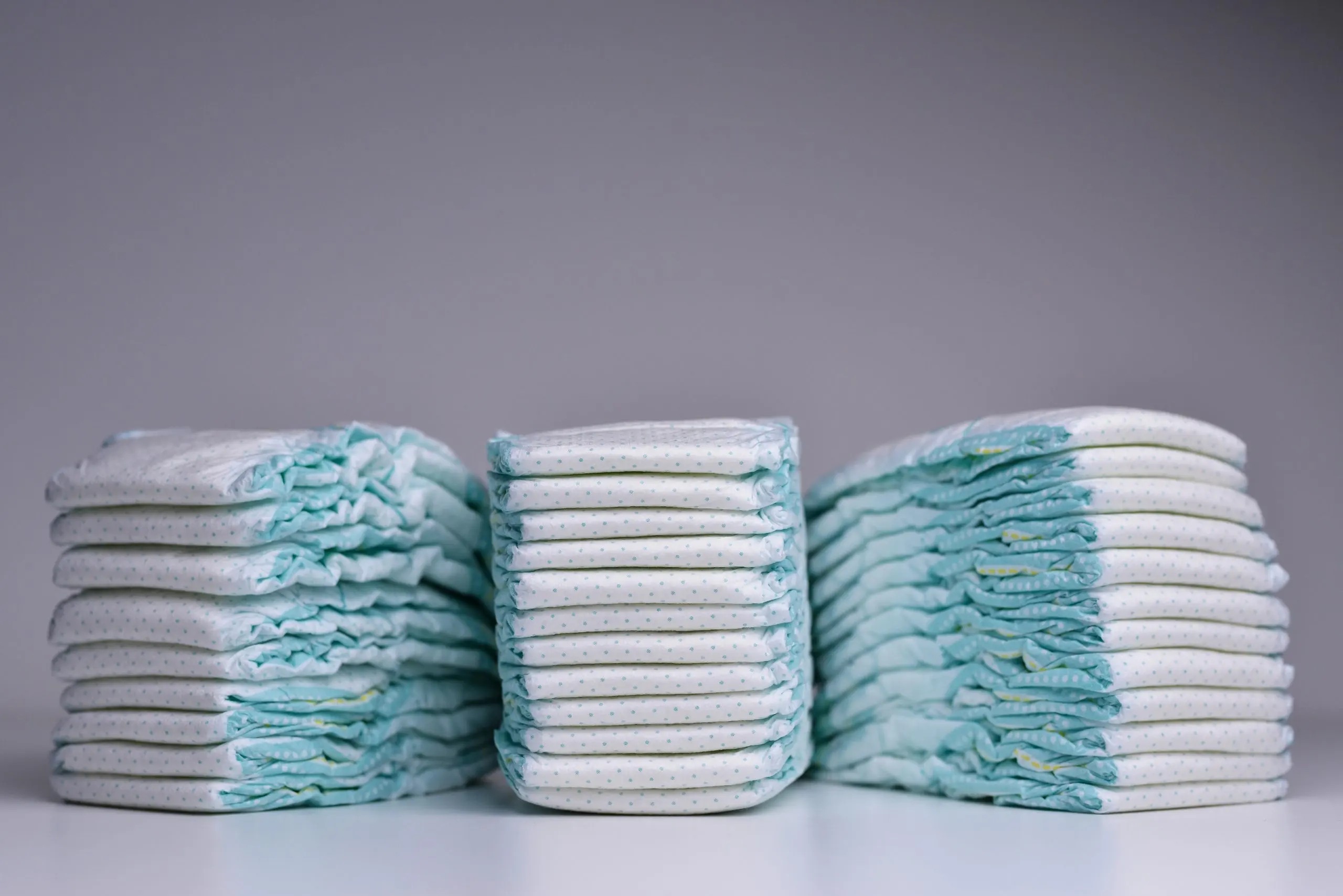India Baby Diapers Market Outlook to 2035 tre-stacks-baby-disposable-nappies-grey-background-scaled