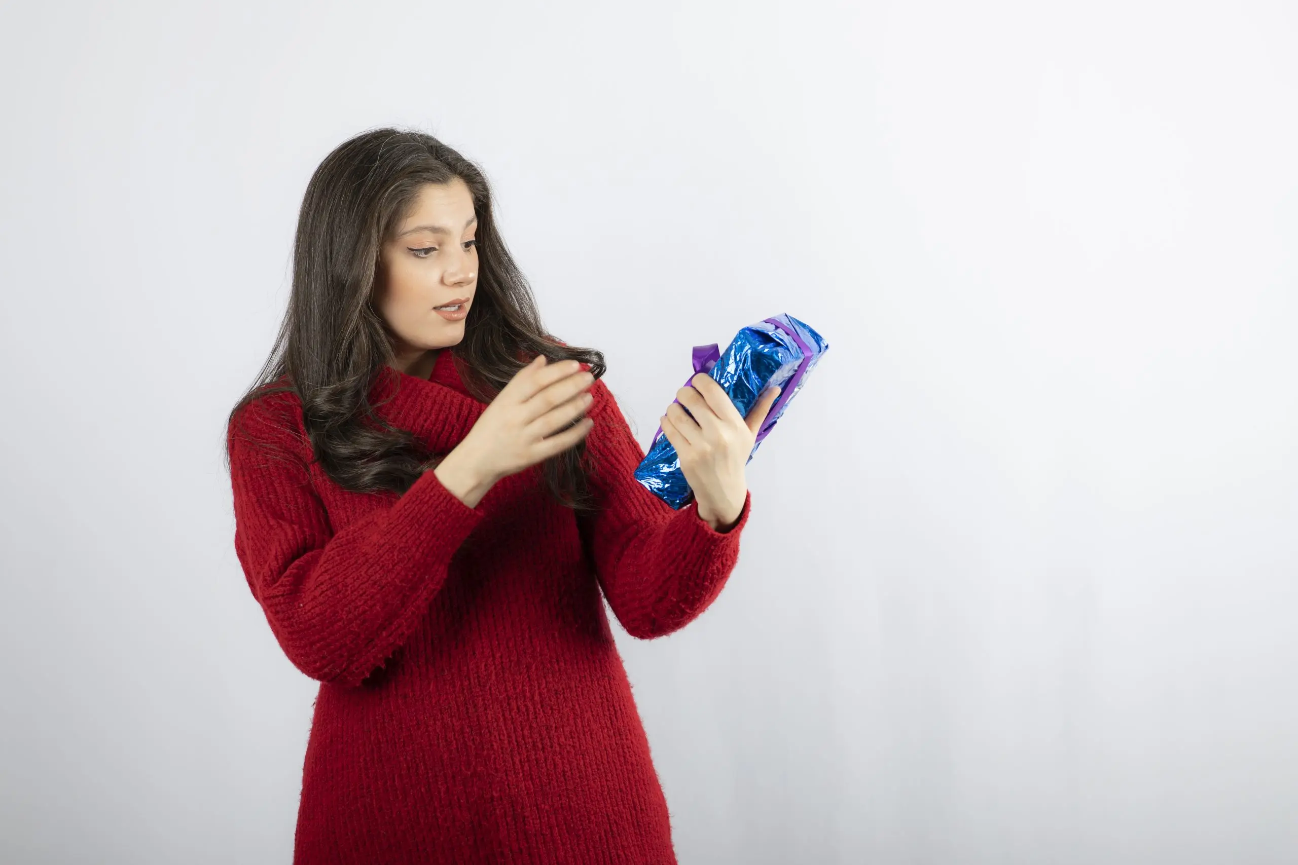 India Feminine Wipes Market Outlook to 2035 woman-excited-about-christmas-gift-box-with-purple-ribbon-scaled
