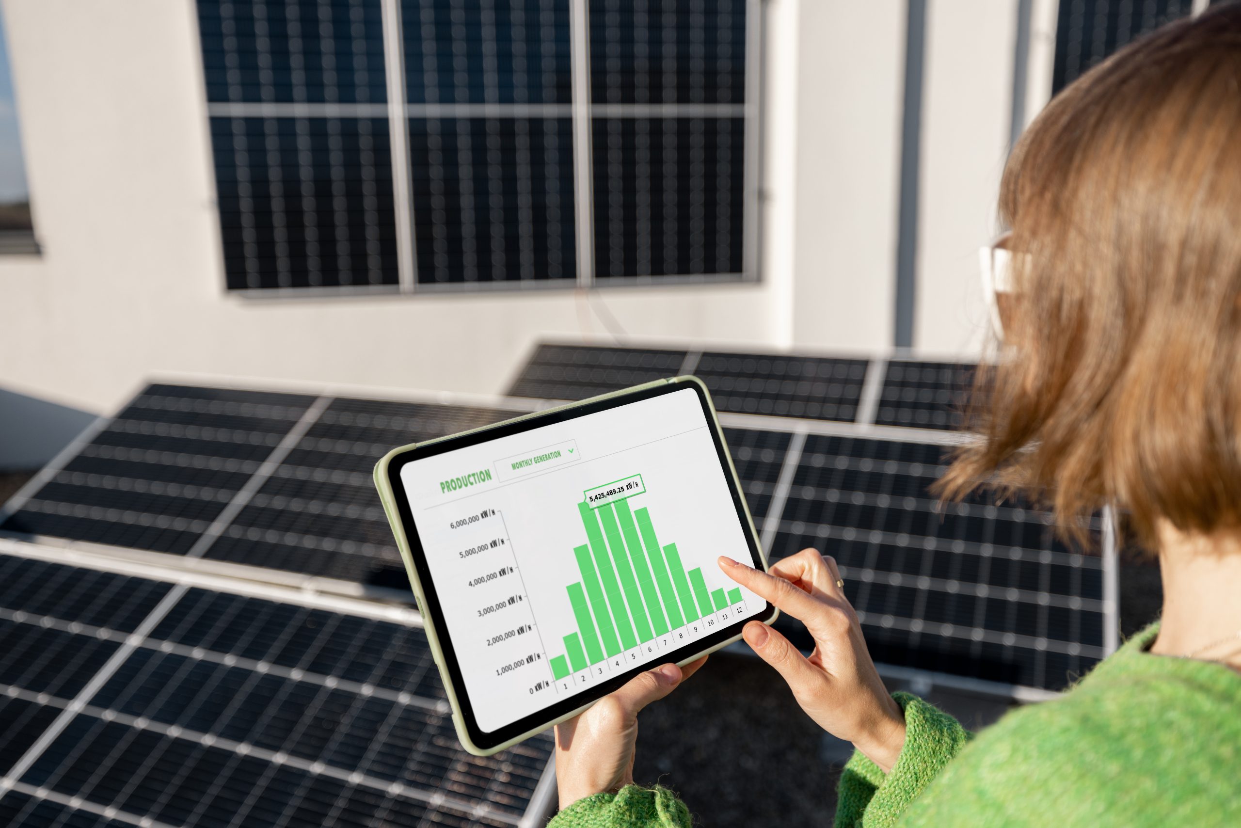 woman-monitors-energy-production-from-solar-power-plant-with-digital-tablet-1-scaled