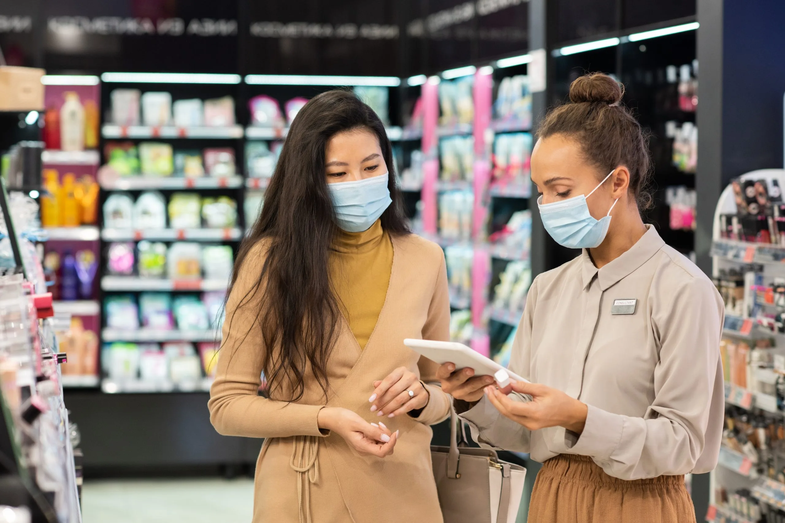 Vietnam Oral Care Market Outlook to 2035 young-consultant-protective-mask-scrolling-tablet-while-looking-price-lip-gloss-wanted-by-one-clients-beauty-supermarket-scaled
