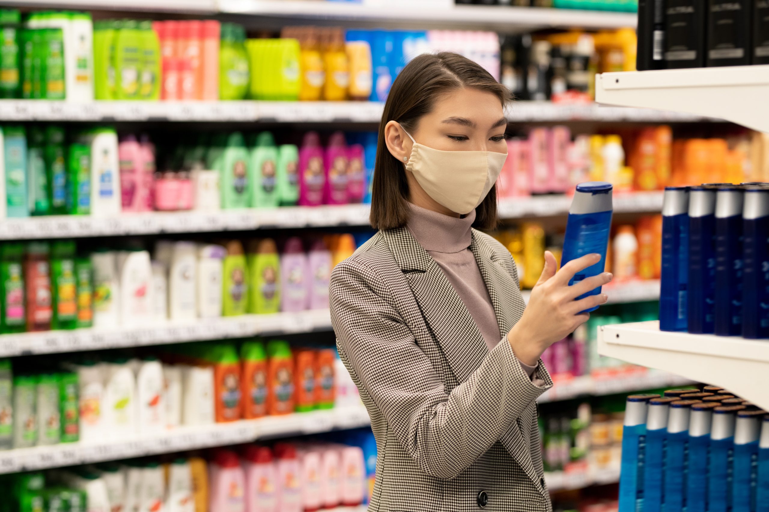 Singapore Face Wash Market Outlook to 2035 young-contemporary-elegant-female-consumer-standing-by-large-shelf-with-shampoos-hair-conditioners-choosing-one-supermarket-scaled