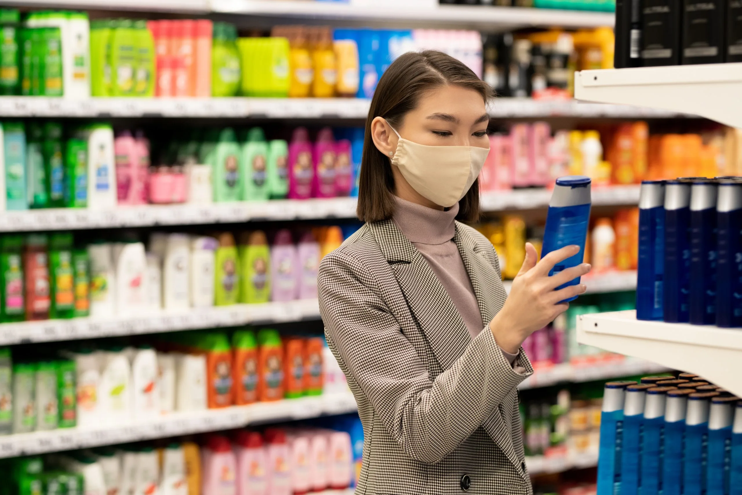 Singapore Face Wash Market Outlook to 2035 young-contemporary-elegant-female-consumer-standing-by-large-shelf-with-shampoos-hair-conditioners-choosing-one-supermarket-scaled